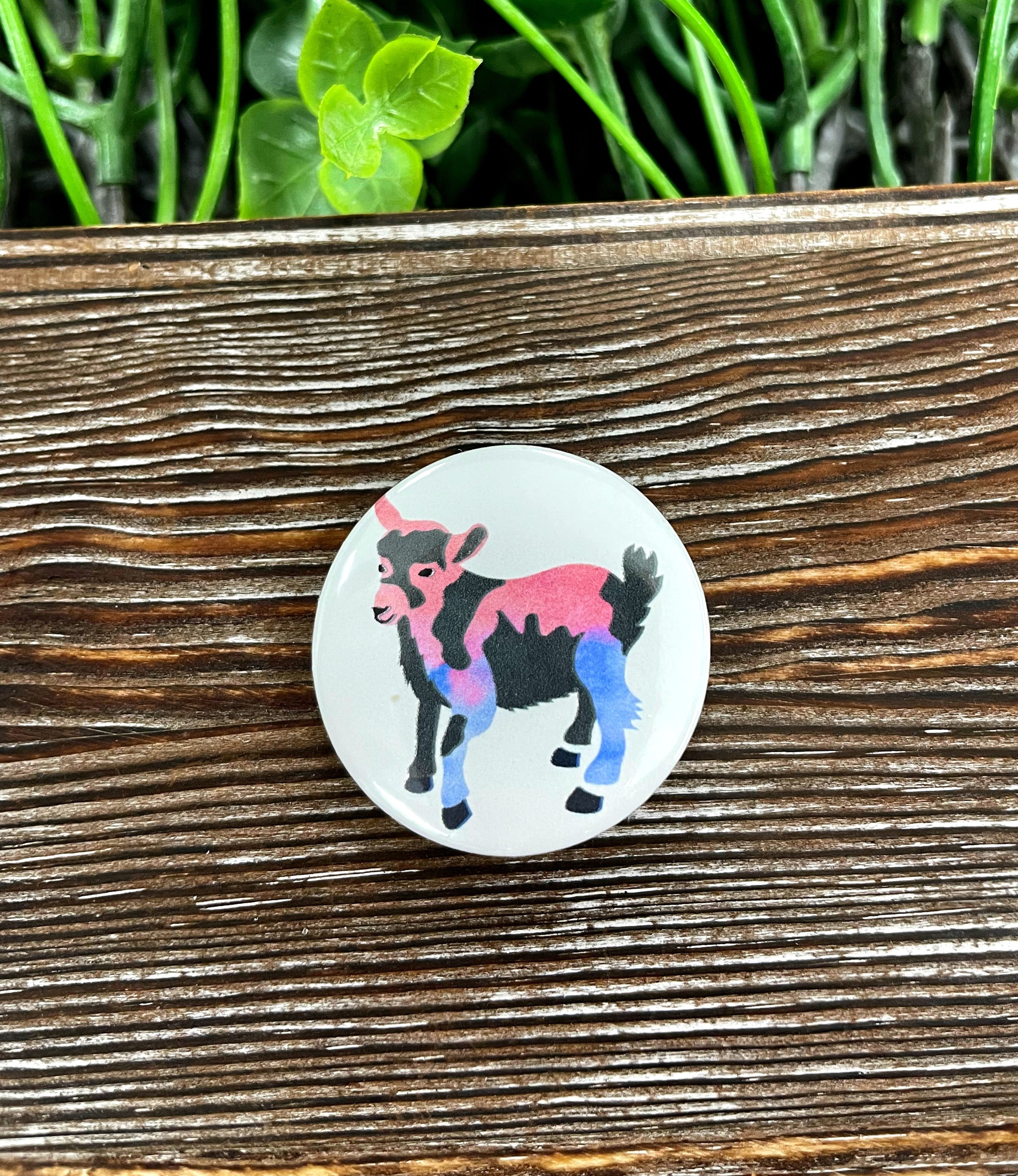 A colorful 1.25-inch button featuring a watercolor goat design, perfect for personalizing bags and accessories.