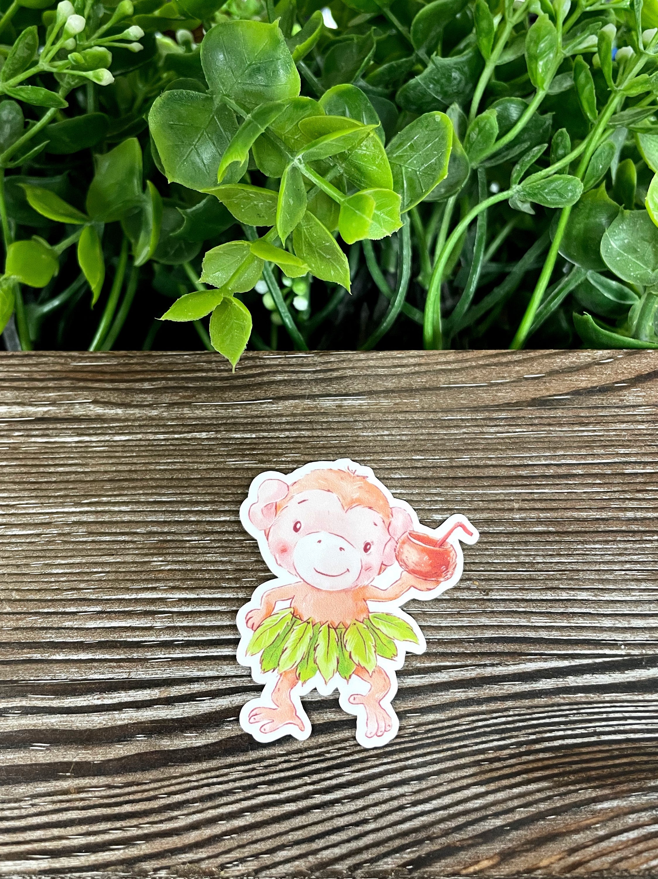 A vibrant watercolor monkey wearing a hula skirt, designed as a die cut vinyl sticker, showcasing bright colors and playful details.