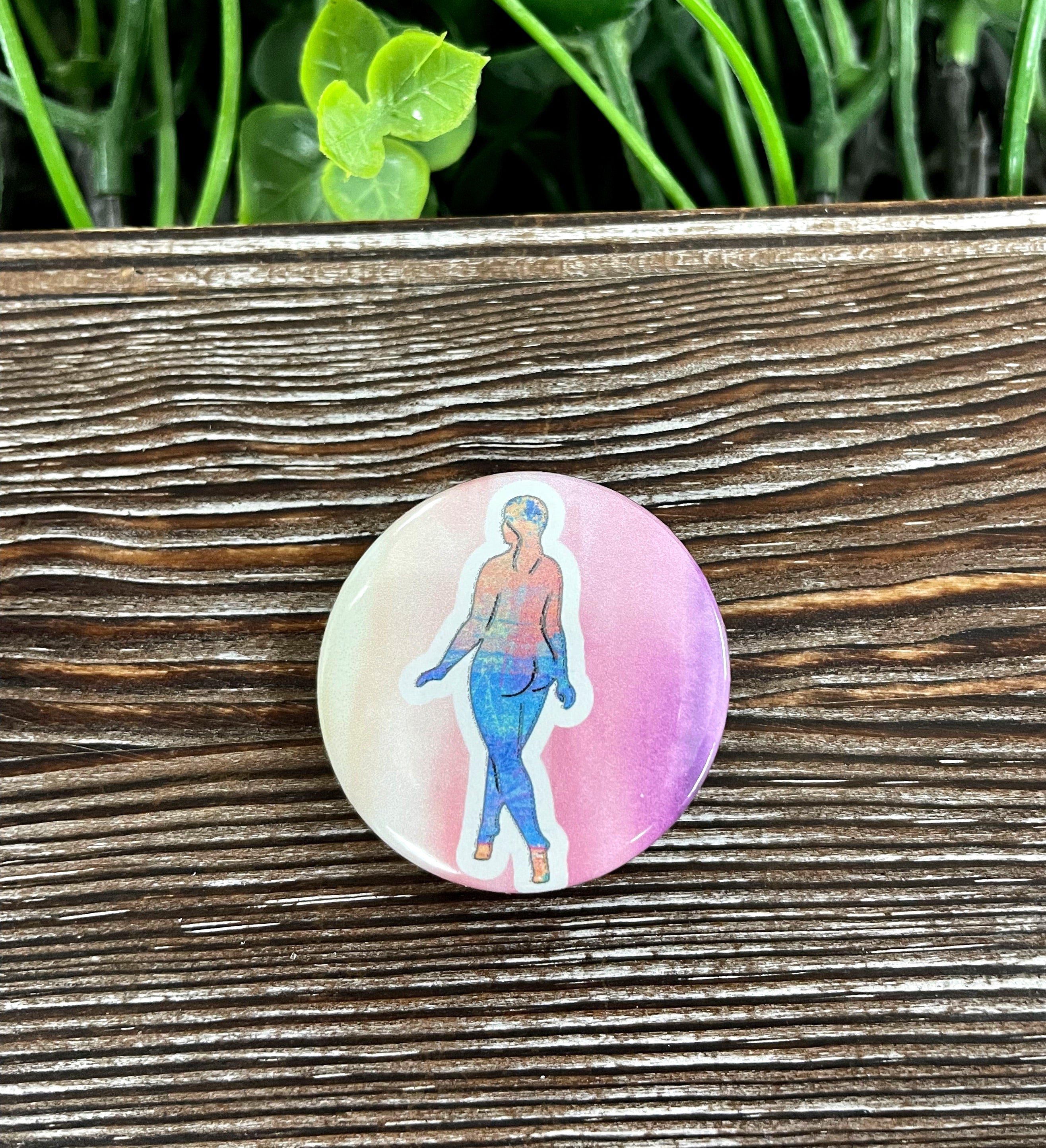 A vibrant 1.25-inch button featuring a watercolor woman silhouette design, perfect for personalizing bags and accessories.