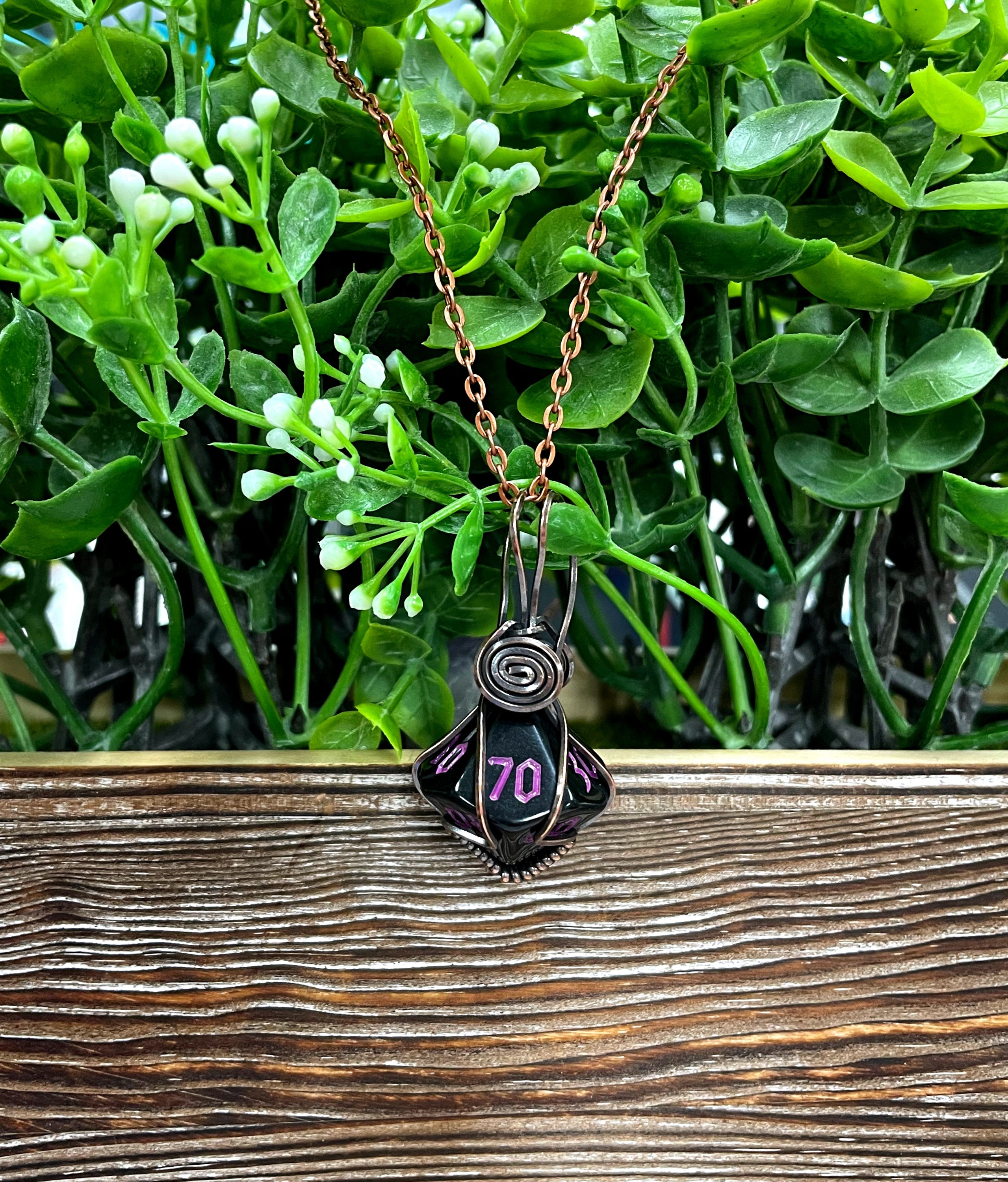 Wire Wrapped D10 Die Pendant featuring multicolored gaming dice wrapped in oxidized copper wire on a suede leather cord.