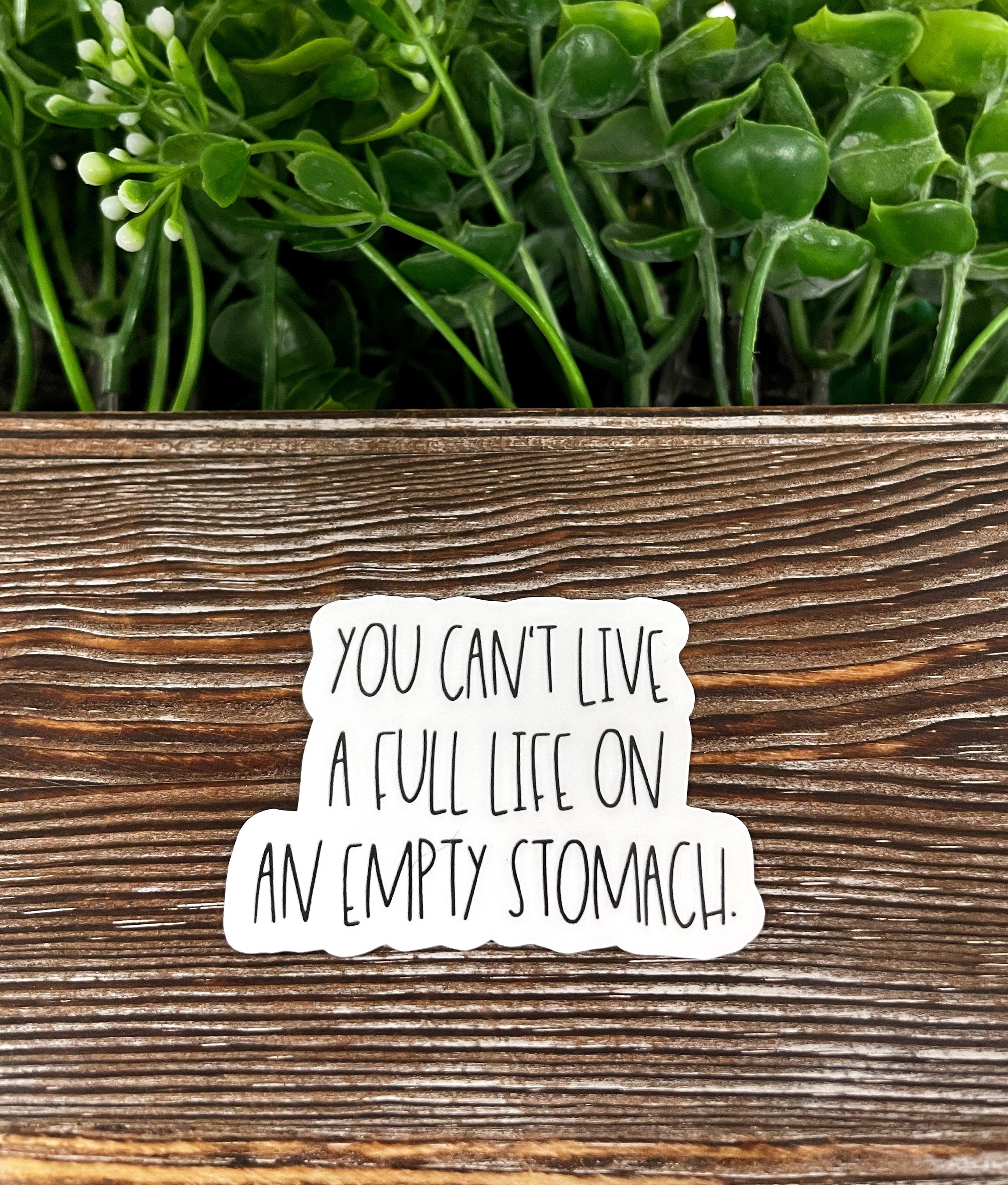 A colorful die cut sticker featuring the phrase 'You Can't Live a Full Life on an Empty Stomach', showcasing its vibrant design and quality finish.