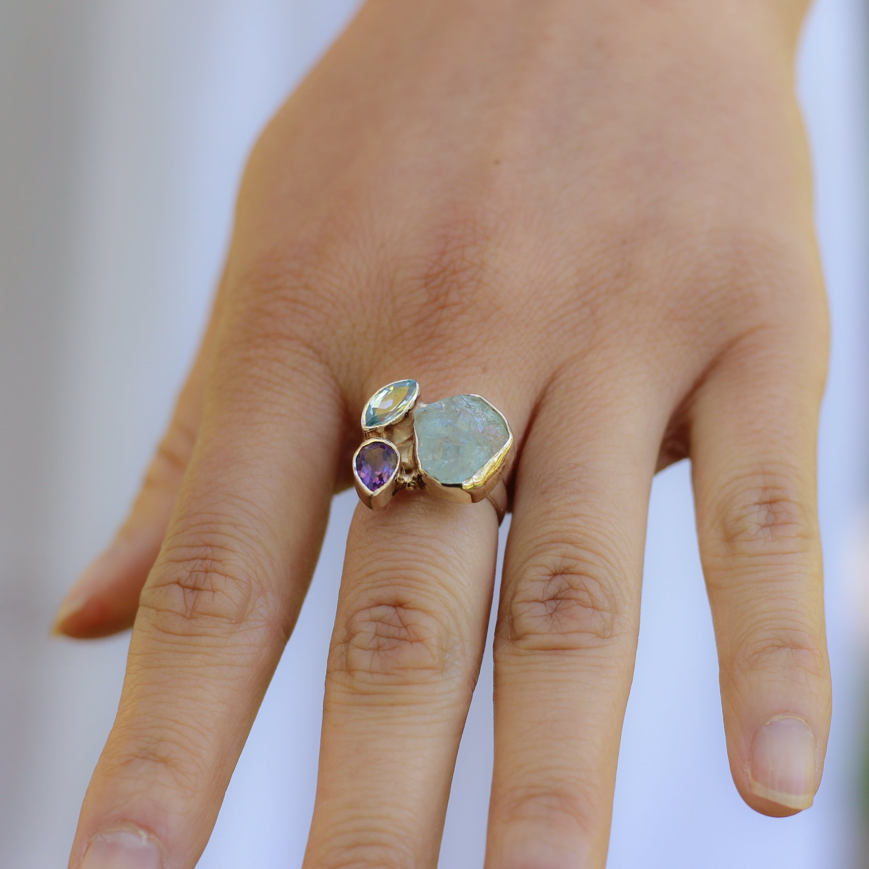 Bague en Argent 925 ornée de Topaze bleue, Aigue-marine et Améthyste, symbolisant lucidité et confiance.