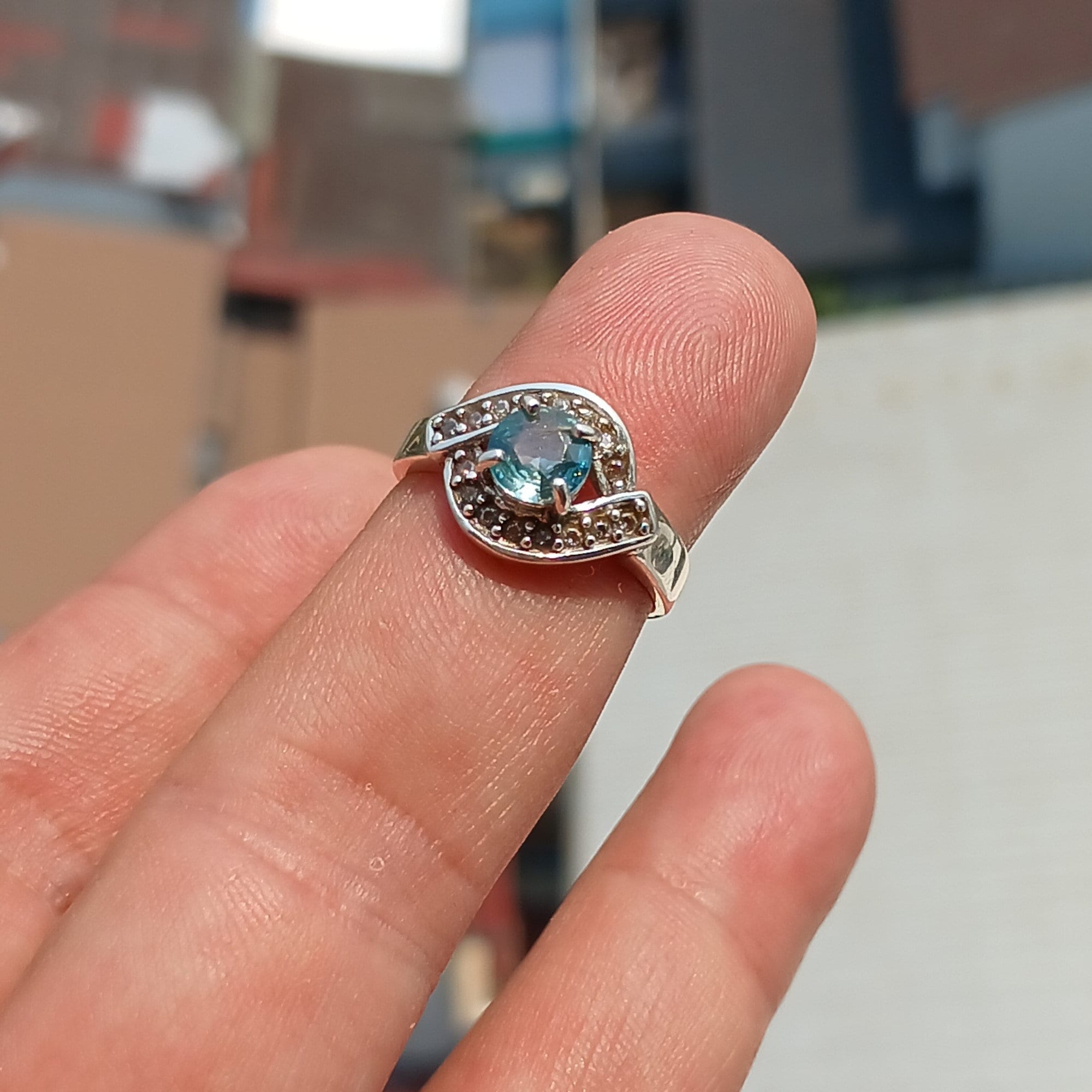 Handmade Blue Zircon Ring in sterling silver with round cut gemstone and CZ accents, showcasing elegance and craftsmanship.