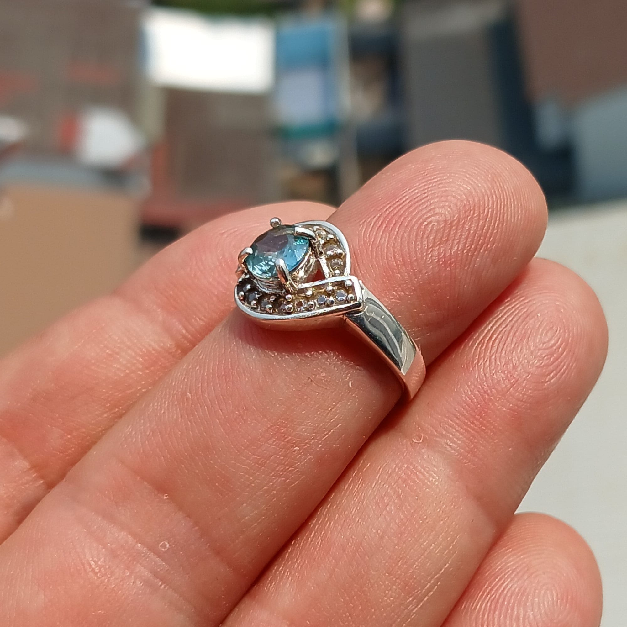 Handmade Blue Zircon Ring in sterling silver with round cut gemstone and CZ accents, showcasing elegance and craftsmanship.
