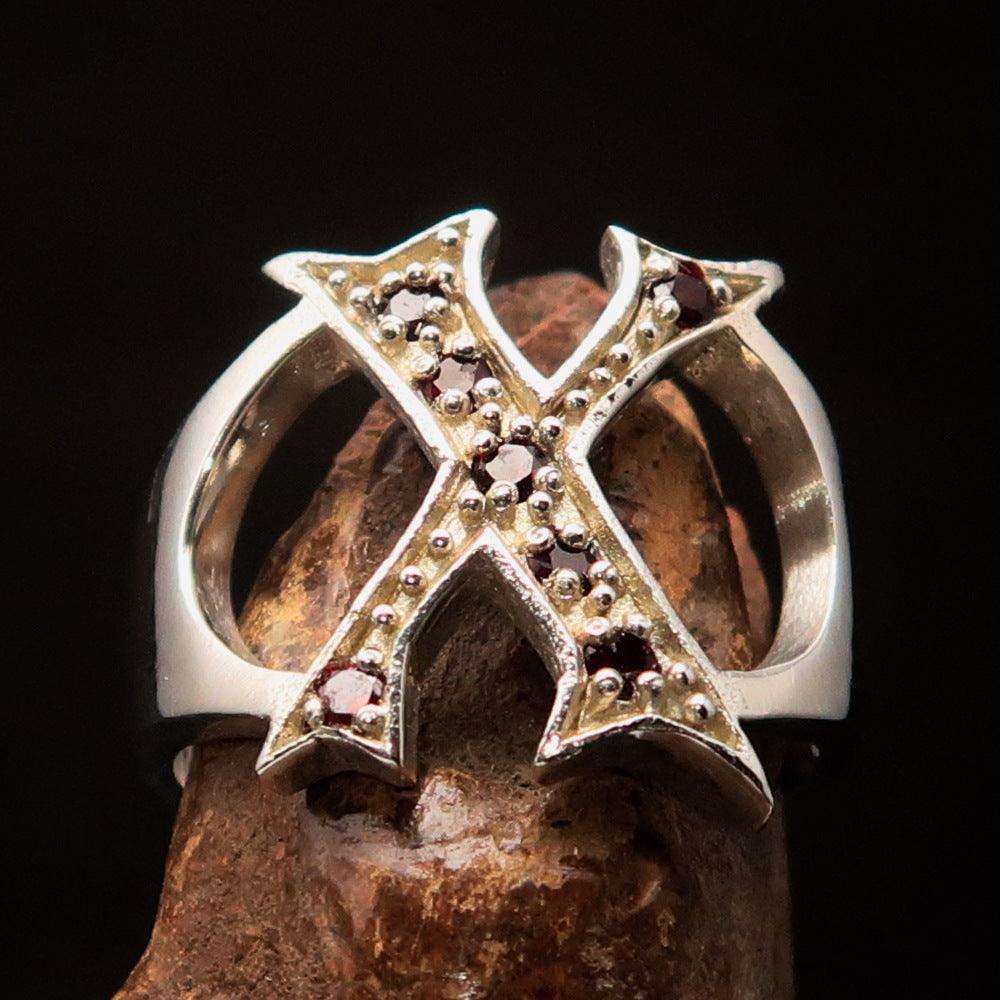 A bold sterling silver initial ring featuring the letter X, adorned with 7 vibrant red cubic zirconia stones, showcasing its elegant design.