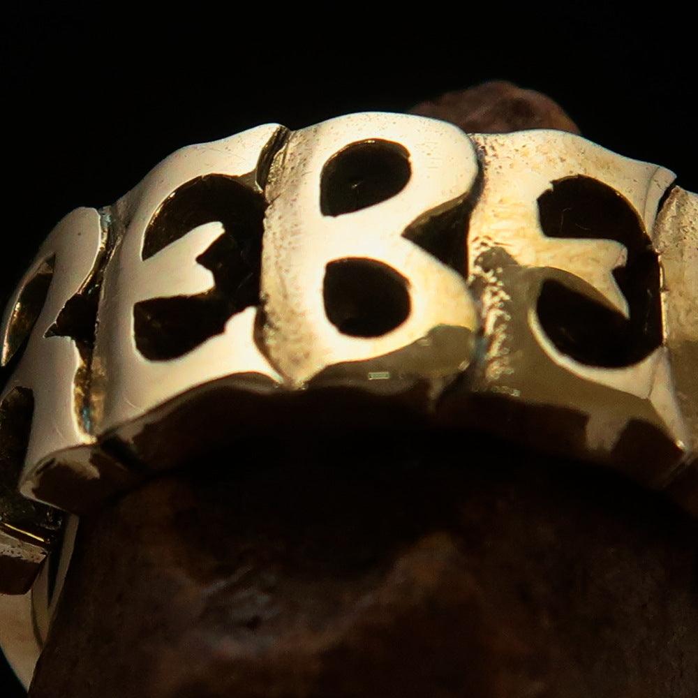 A high-polished solid brass One Word REBEL Ring, showcasing its elegant design and bold statement.