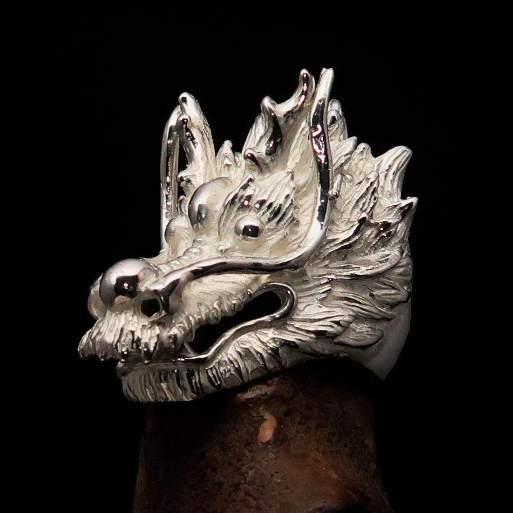 A shiny sterling silver men's ring featuring an intricate dragon design, showcasing its detailed craftsmanship and luxurious finish.