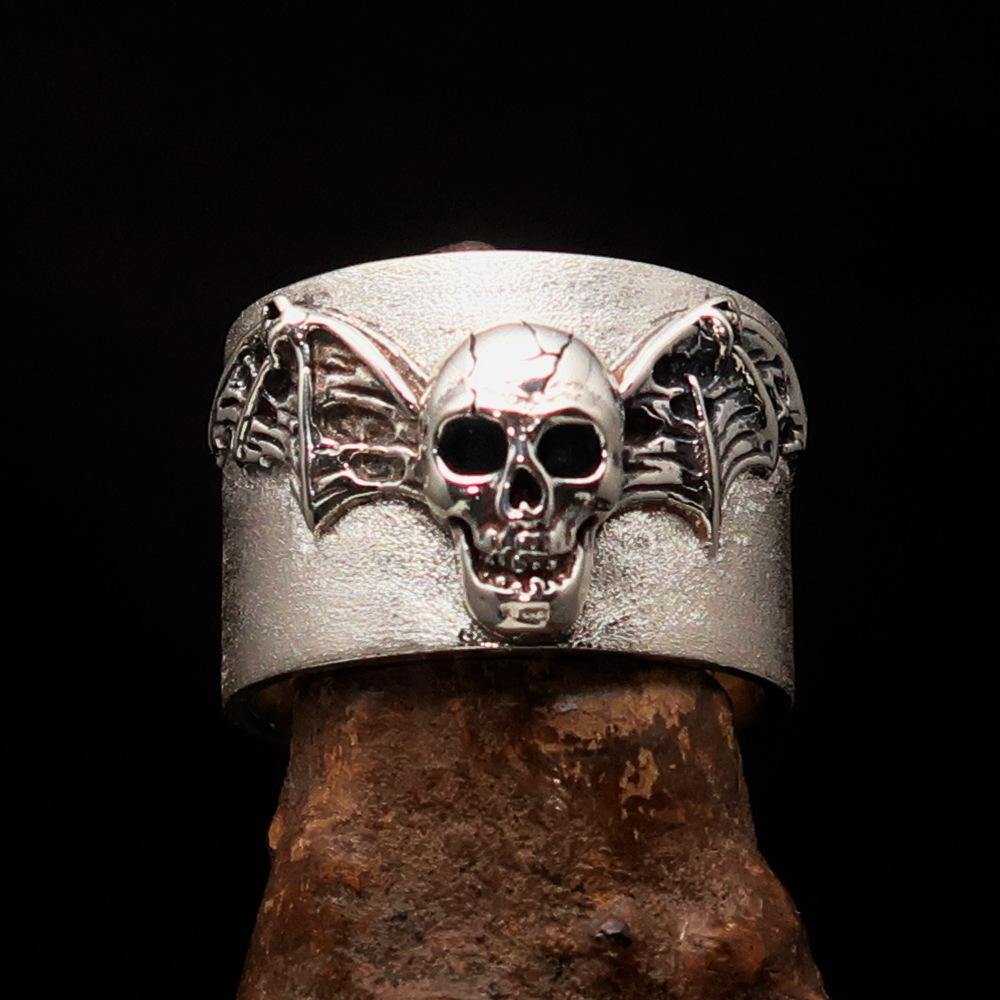 A beautifully crafted two tone winged bat skull ring made of matte sterling silver, showcasing intricate details and a unique design.
