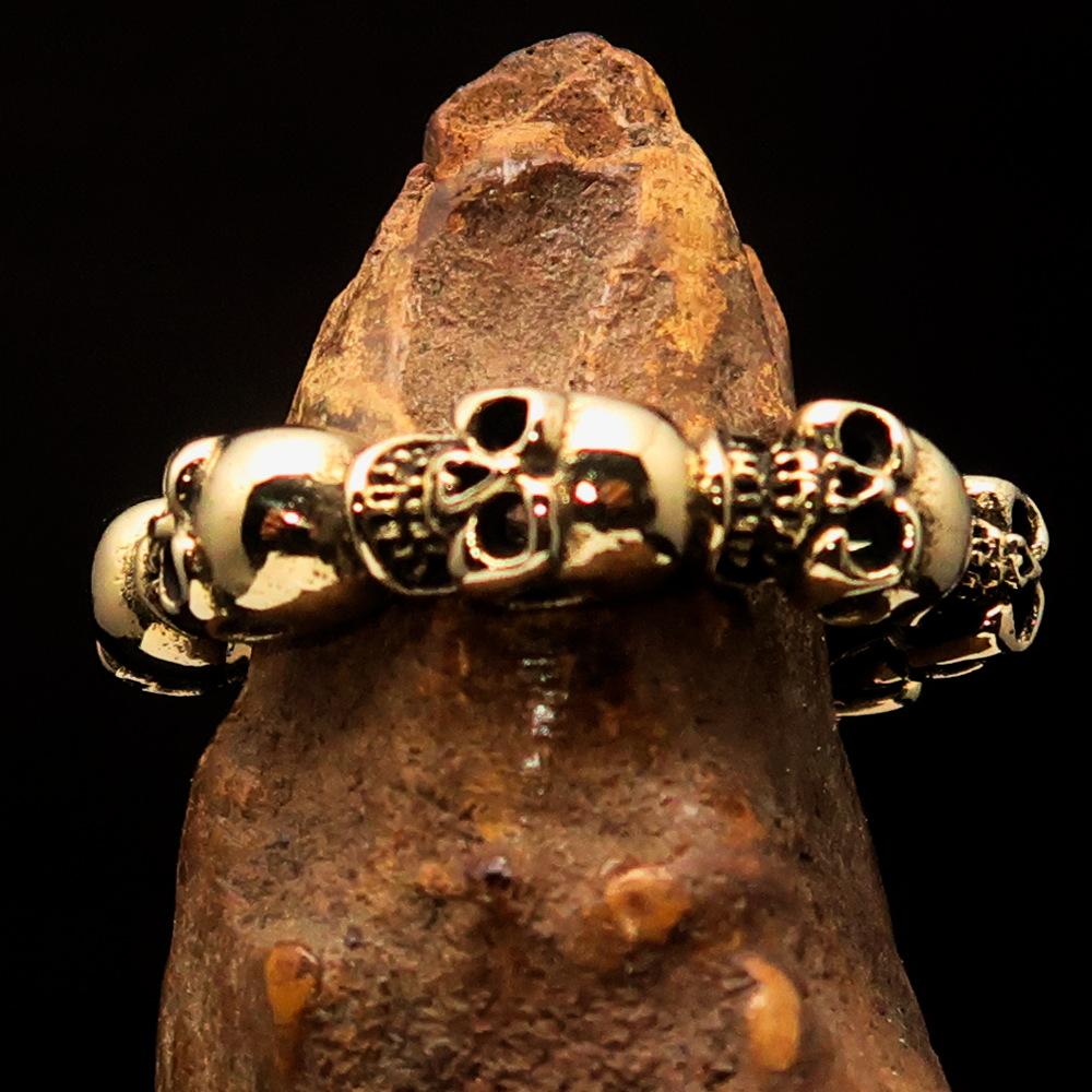 Excellent Men's Brass Biker Band Ring featuring six detailed skulls, showcasing a polished and antiqued finish.