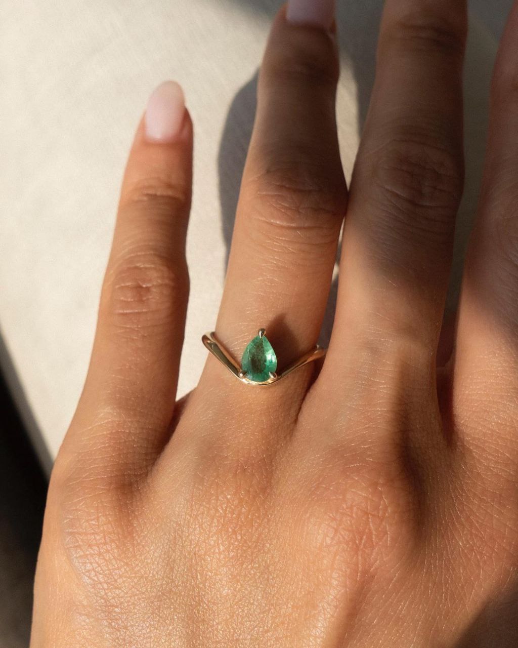 Gold plated silver ring featuring a pear-shaped lab-grown green emerald, showcasing its vibrant color and elegant design.