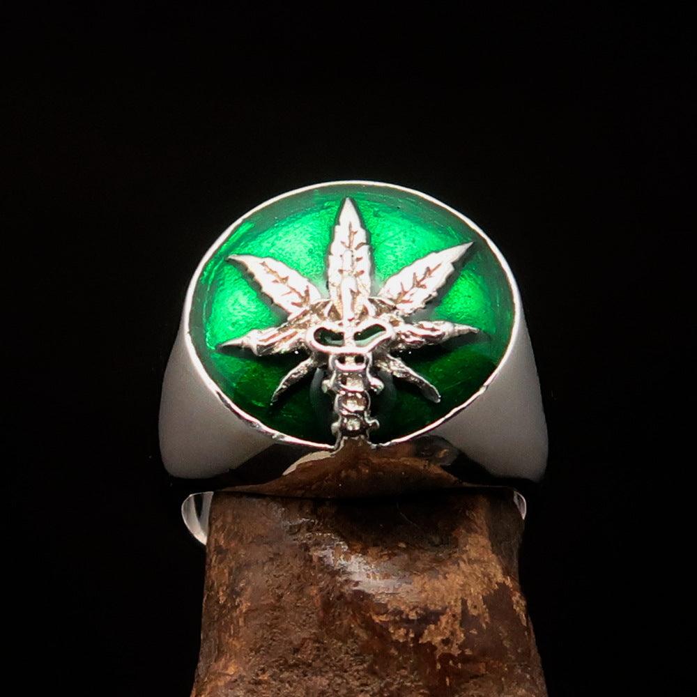 Men's sterling silver ring featuring a cannabis leaf design with green enamel finish, showcasing its polished surface and intricate details.