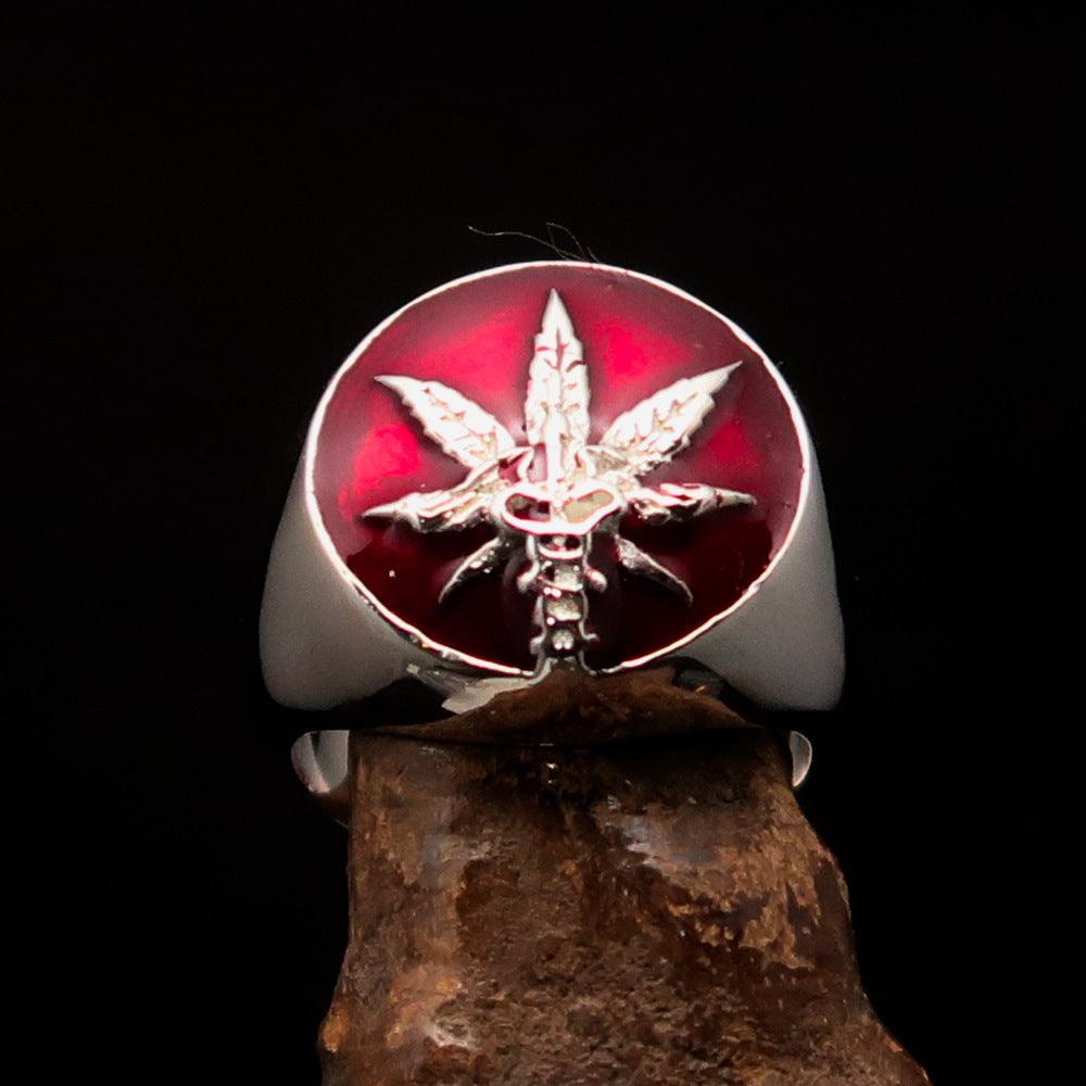 Men's sterling silver ring featuring a cannabis leaf symbol with red enamel, hallmarked 925, showcasing intricate design.