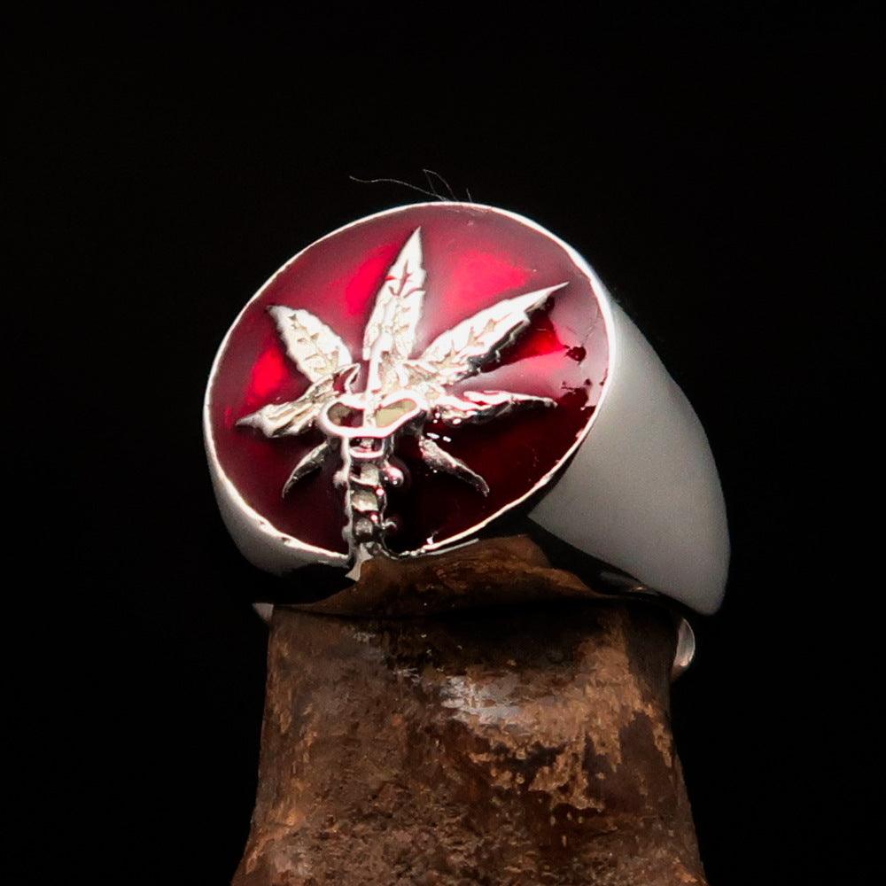 Men's sterling silver ring featuring a cannabis leaf symbol with red enamel, hallmarked 925, showcasing intricate design.