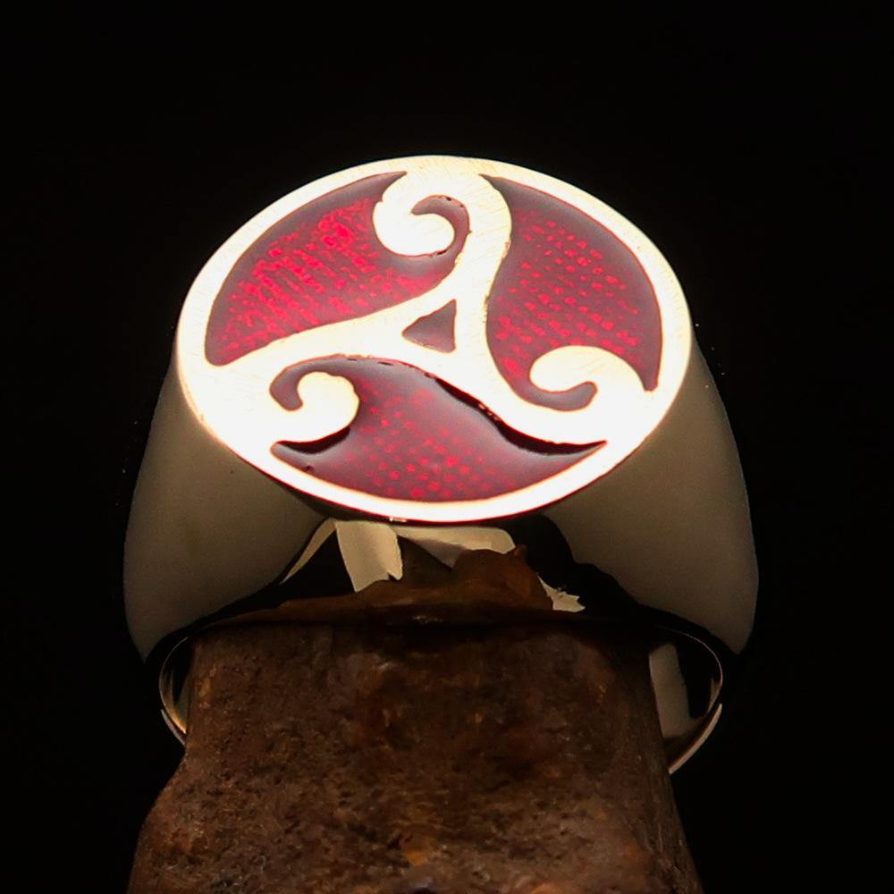 Men's Celtic Triade Ring made of solid brass with red enamel triskele design, showcasing its polished finish and intricate details.