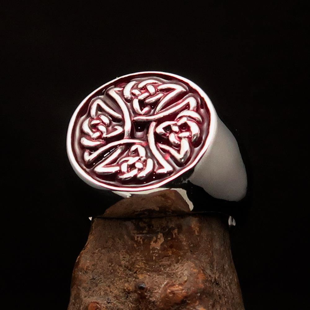 Men's sterling silver ring featuring Celtic Birgit's Cross design with red enamel, showcasing intricate craftsmanship.