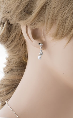 Elegant bridal jewelry set featuring white pearls and sparkling crystals, including a necklace and matching earrings, beautifully displayed.