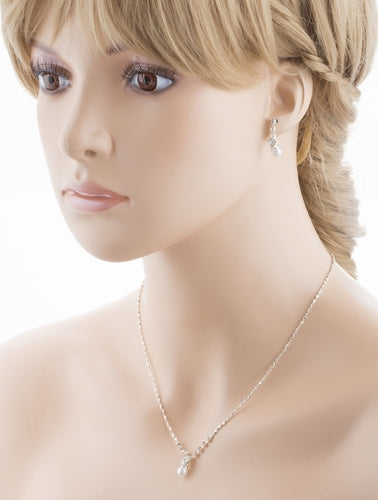 Elegant bridal jewelry set featuring white pearls and sparkling crystals, including a necklace and matching earrings, beautifully displayed.