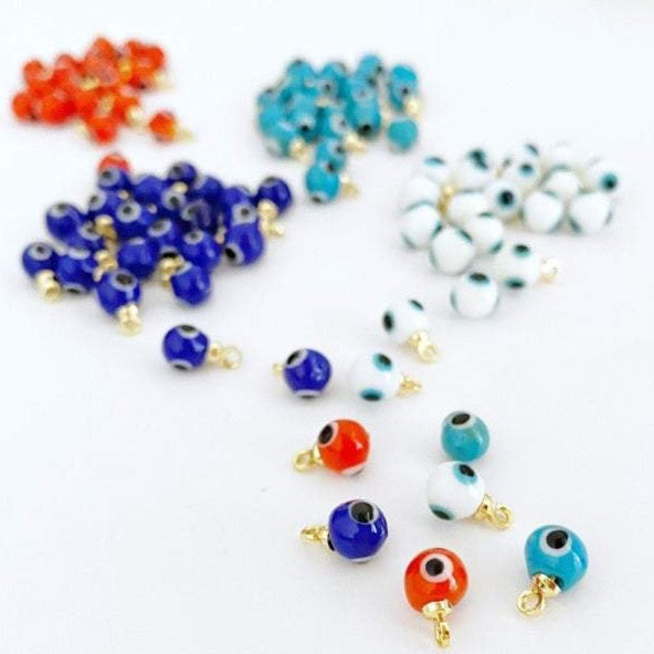 A collection of tiny glass evil eye beads in various colors, showcasing their intricate designs and craftsmanship, perfect for DIY jewelry making.
