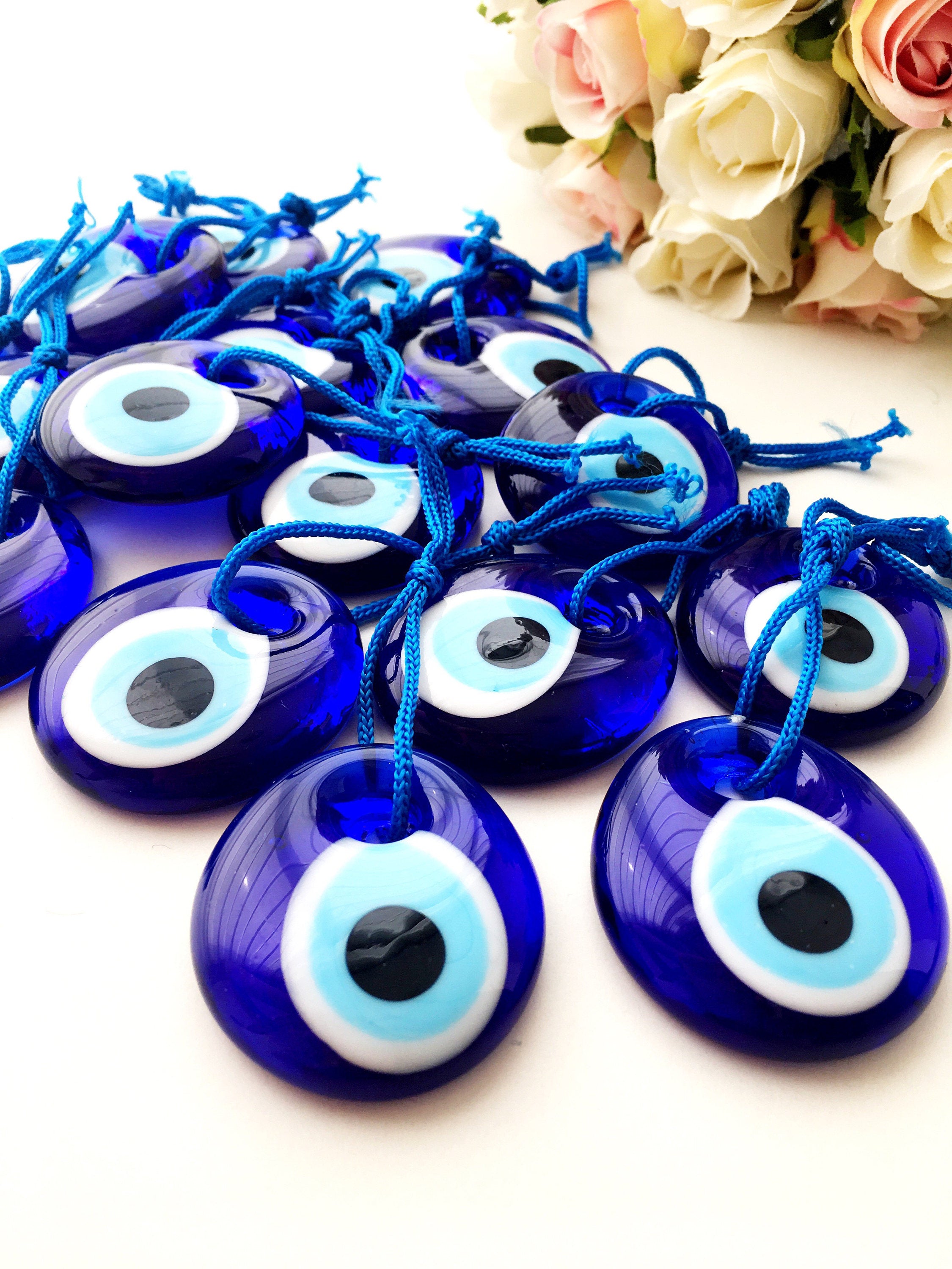 A collection of 100 blue glass evil eye charm beads, each 4.5cm, with blue ropes for hanging, symbolizing protection and good luck.