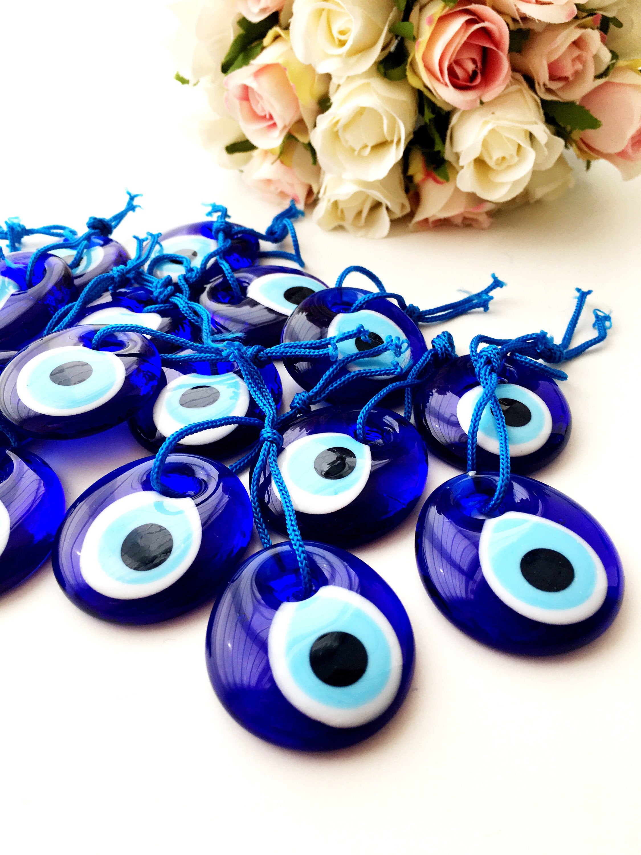 A collection of 100 blue glass evil eye charm beads, each 4.5cm, with blue ropes for hanging, symbolizing protection and good luck.