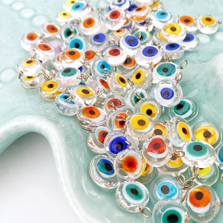 A collection of 10 handmade Murano glass evil eye beads in various colors, featuring a clear evil eye charm design.