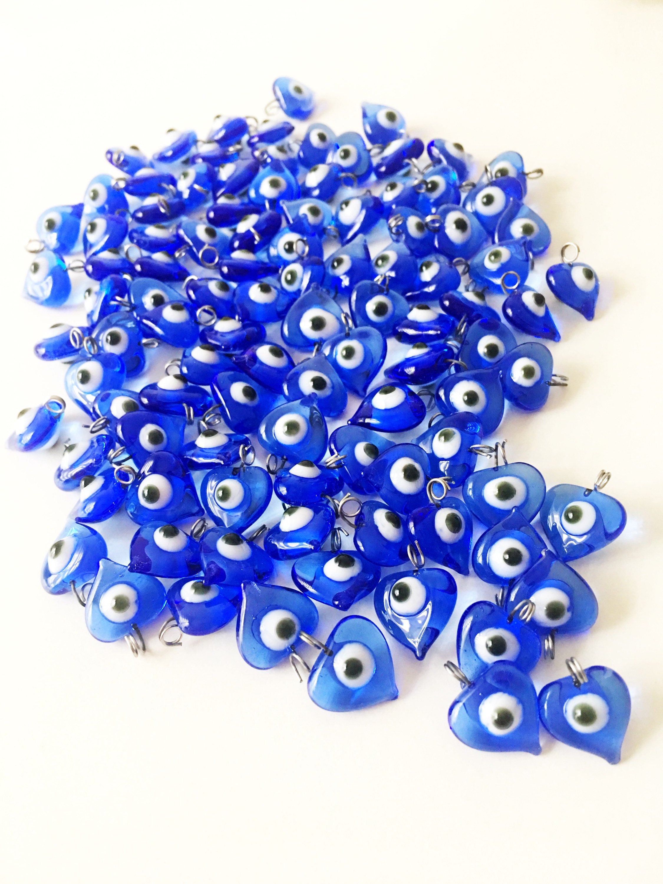 A collection of 10 blue glass evil eye charms with metal hooks, symbolizing protection and good luck, ideal for wedding favors and DIY jewelry.