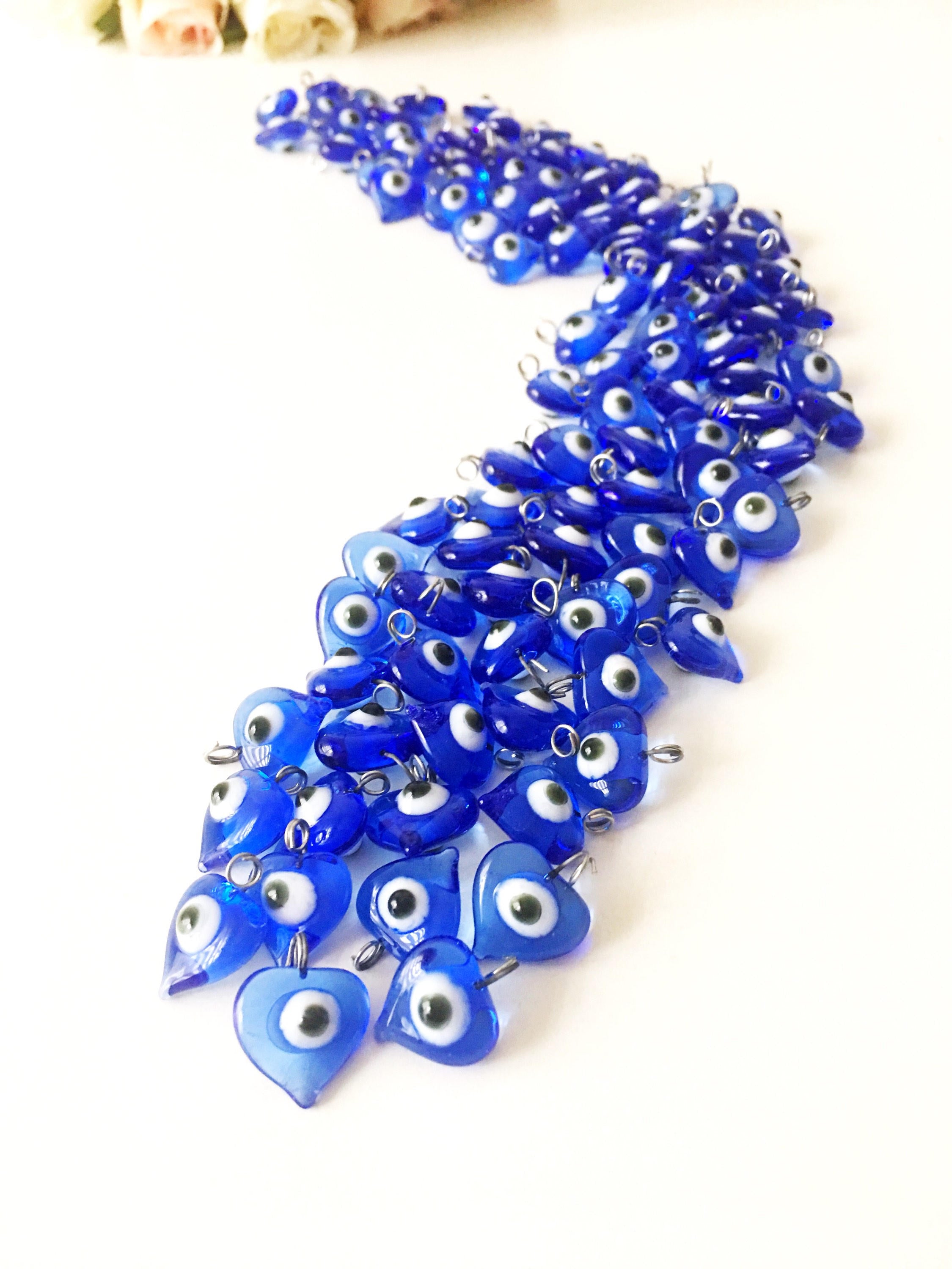 A collection of 10 blue glass evil eye charms with metal hooks, symbolizing protection and good luck, ideal for wedding favors and DIY jewelry.