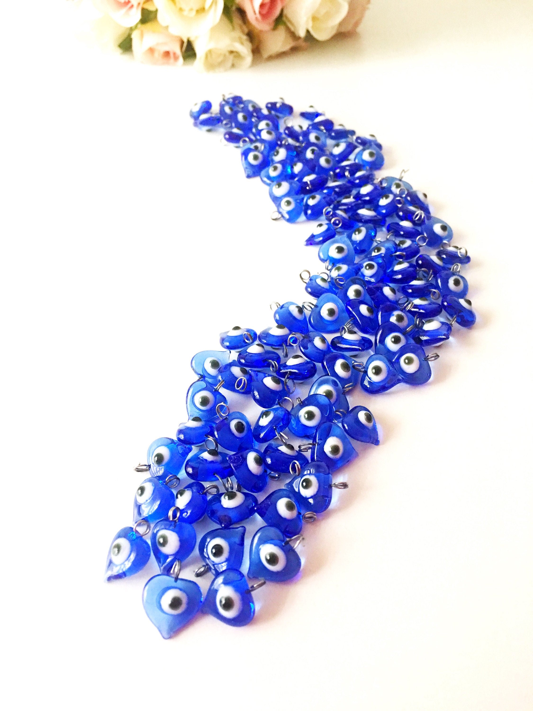 A collection of 10 blue glass evil eye charms with metal hooks, symbolizing protection and good luck, ideal for wedding favors and DIY jewelry.