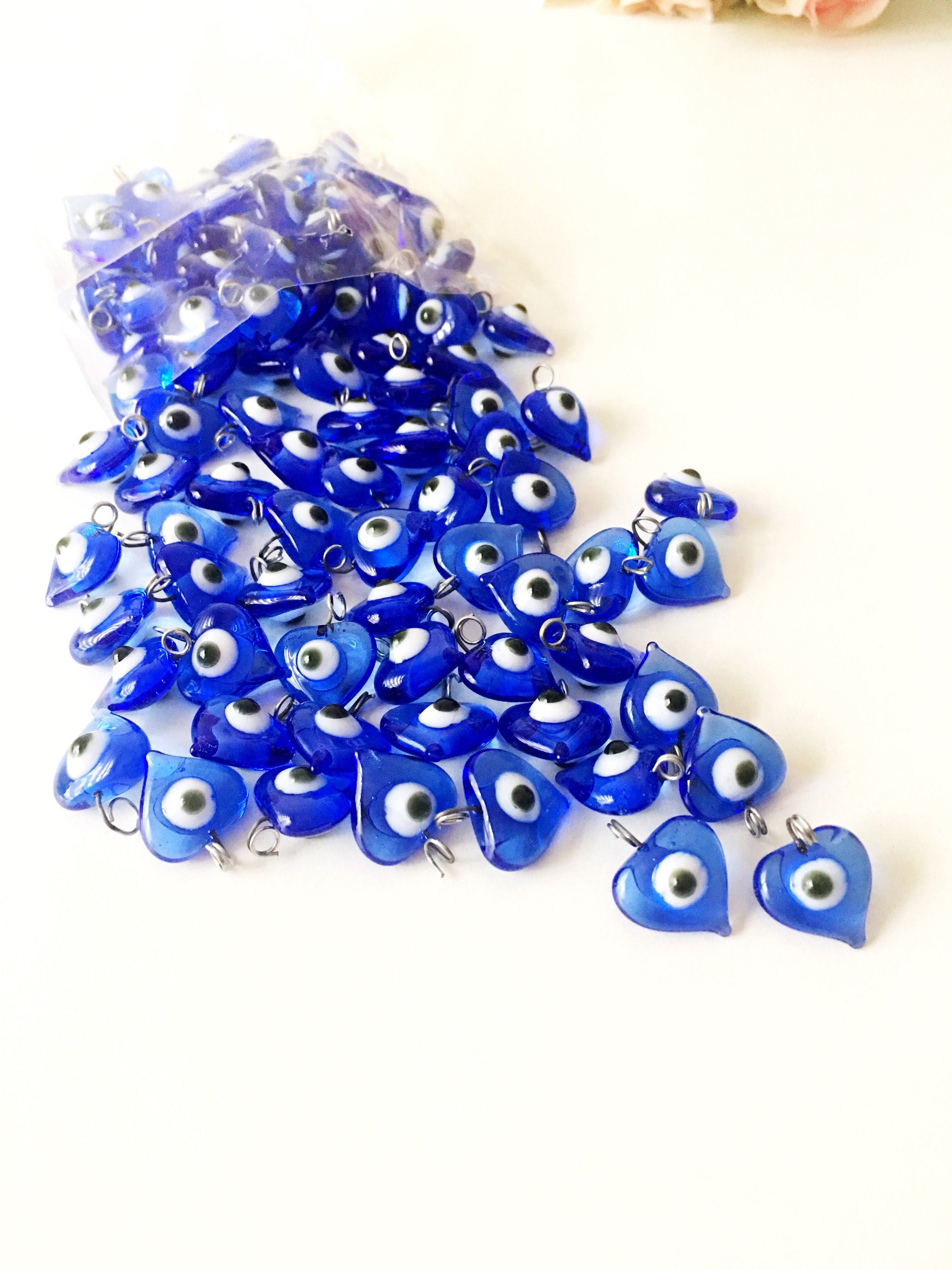 A collection of 10 blue glass evil eye charms with metal hooks, symbolizing protection and good luck, ideal for wedding favors and DIY jewelry.