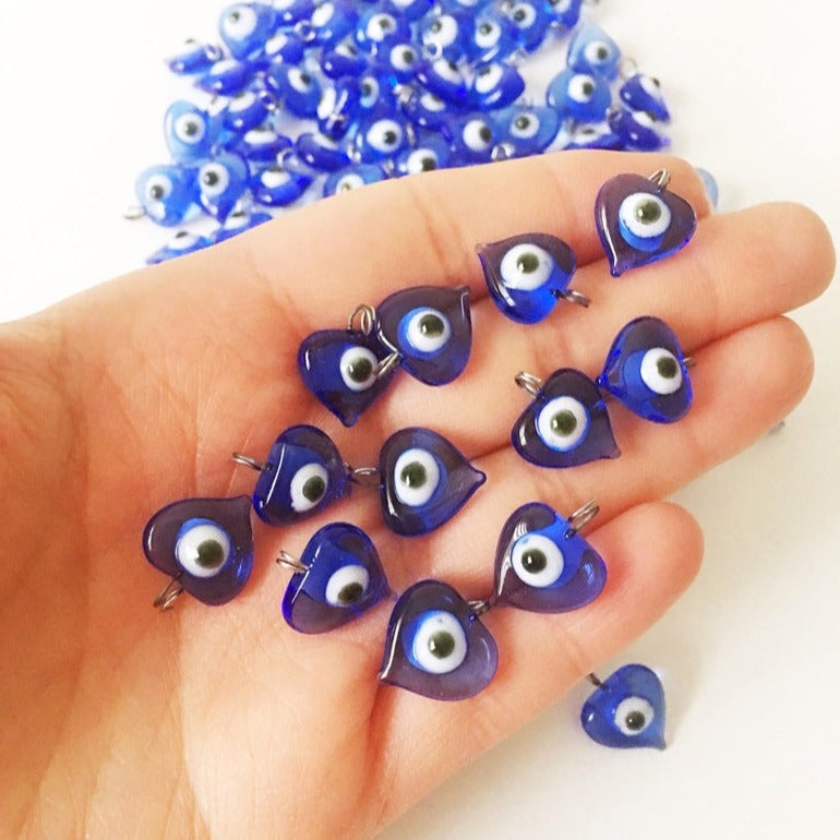 A collection of 100 unique blue evil eye charms with hooks, perfect for wedding favors and DIY jewelry projects.