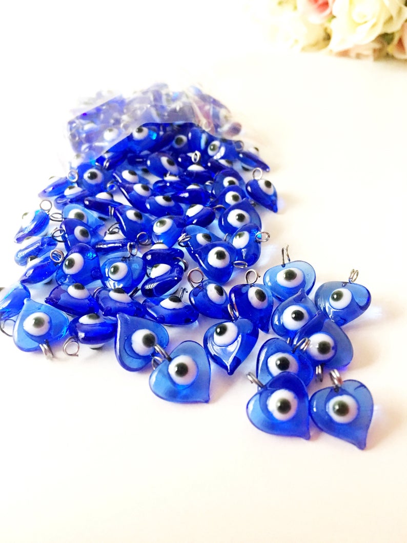 A collection of 100 unique blue evil eye charms with hooks, perfect for wedding favors and DIY jewelry projects.