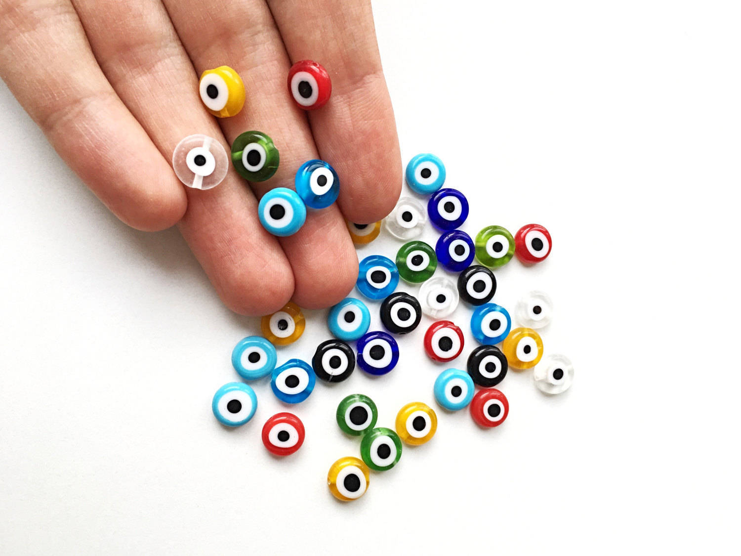 A collection of 100 pieces of 10mm multicolored evil eye beads, showcasing their flat round shape and vibrant designs.