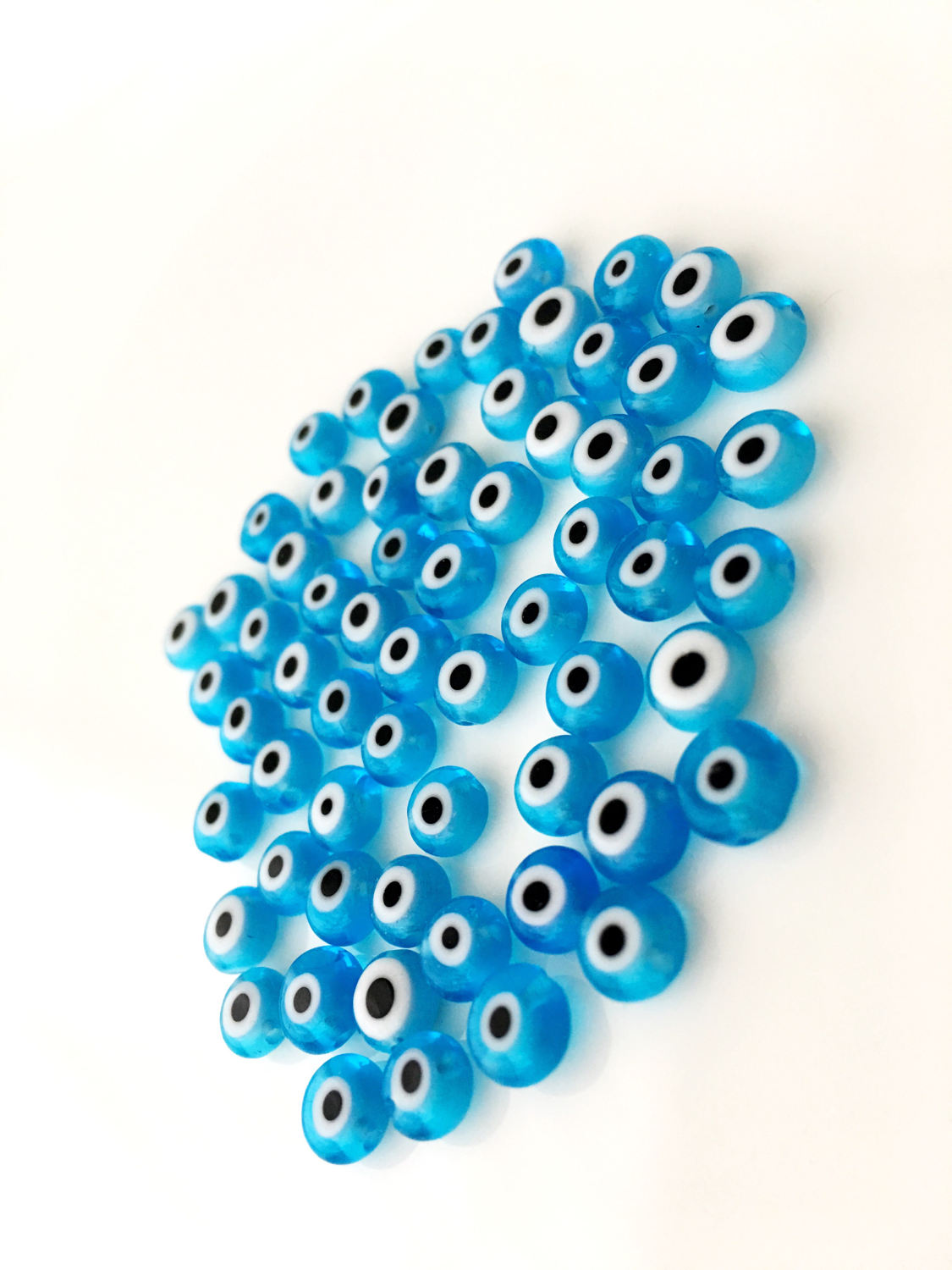 A collection of 120 turquoise glass evil eye beads in various sizes from 6mm to 12mm, showcasing their unique handmade designs.