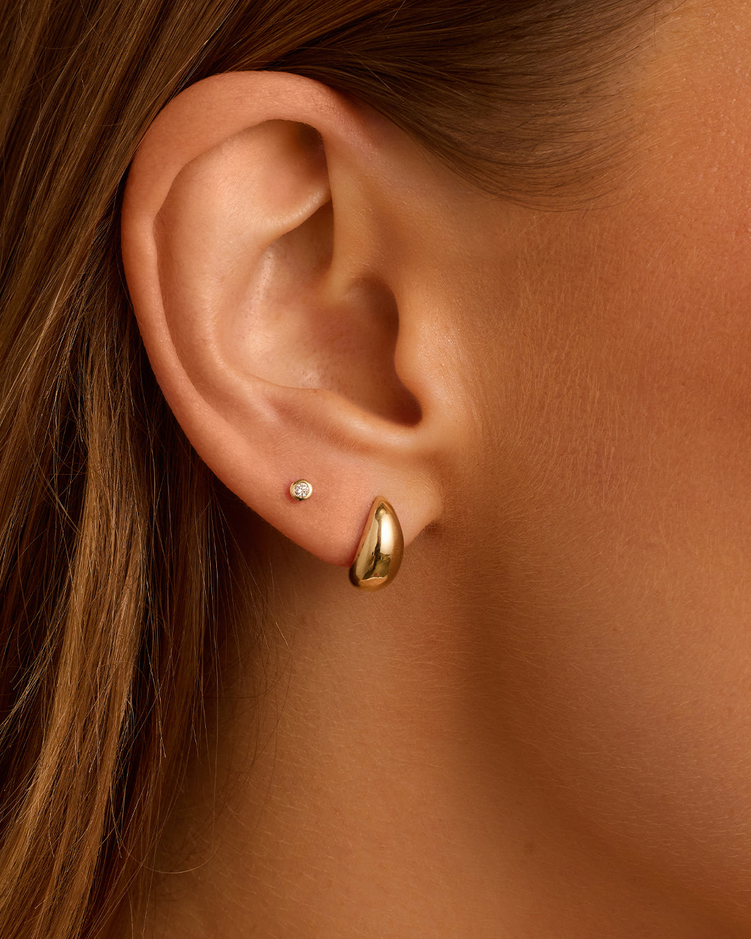 A pair of elegant 14k gold Banks Studs, showcasing their delicate yet bold design, perfect for any occasion.