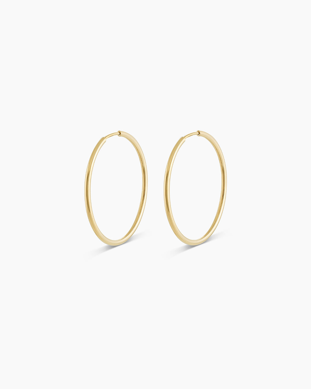A pair of elegant 14k gold classic hoop earrings, showcasing their radiant shine and timeless design.