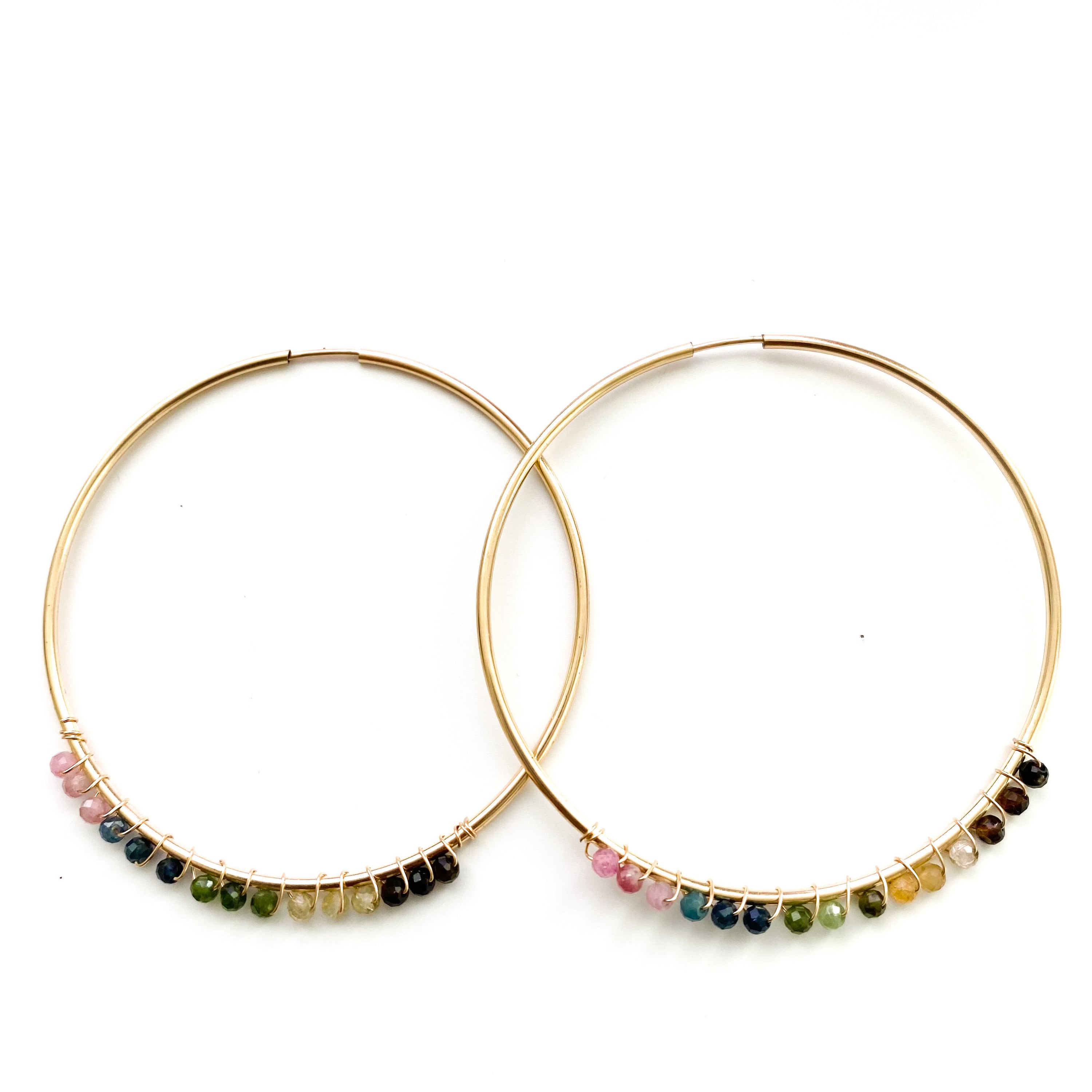 Elegant 14K gold filled hoop earrings adorned with tiny gemstone beads, showcasing a beautiful infinity design.