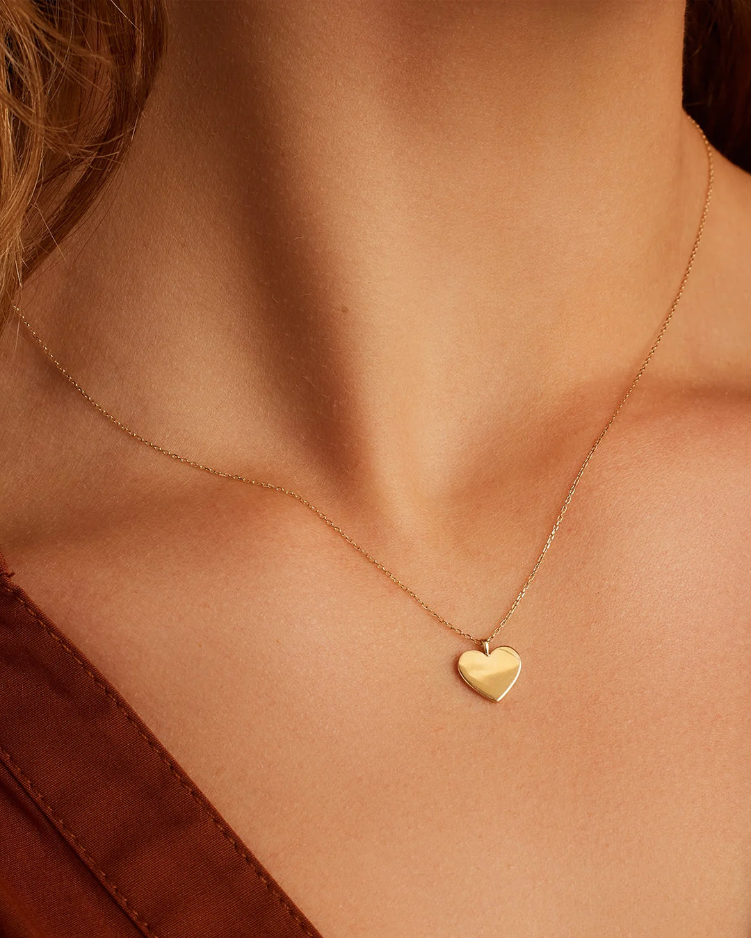 A beautiful 14k gold heart necklace showcasing its delicate design and luxurious shine.