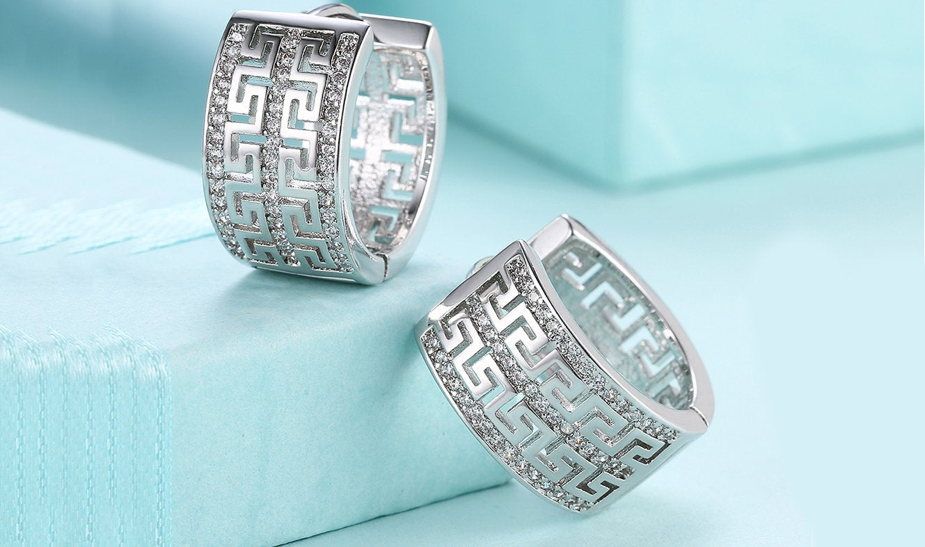 Elegant 14K gold plated hinge earrings featuring intricate laser cut Celtic design with white Austrian elements.