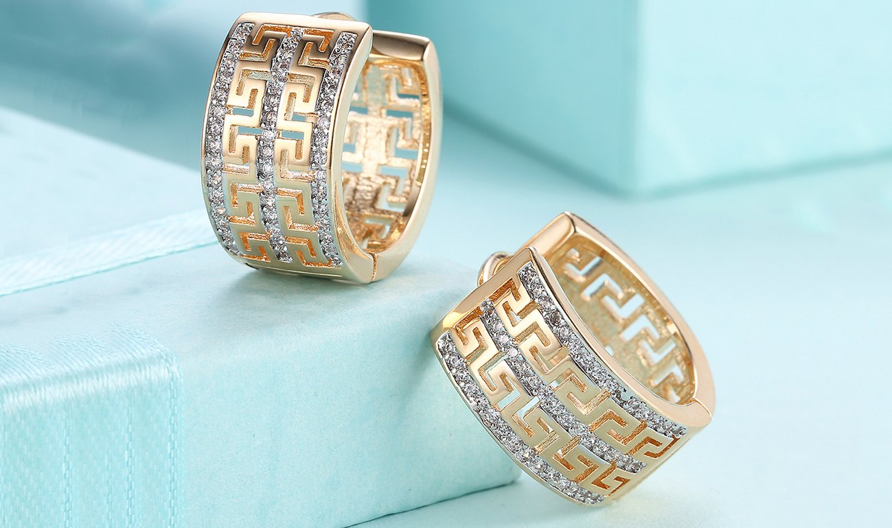 Elegant 14K gold plated hinge earrings featuring intricate laser cut Celtic design with white Austrian elements.