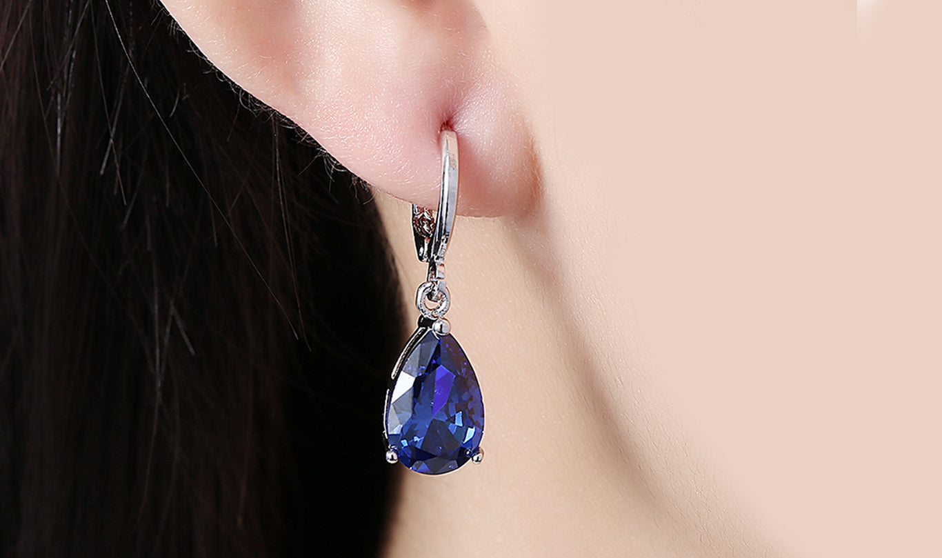 Elegant 14K gold plated pear cut drop earrings in blue, purple, and white options, showcasing their sleek design and high-quality craftsmanship.