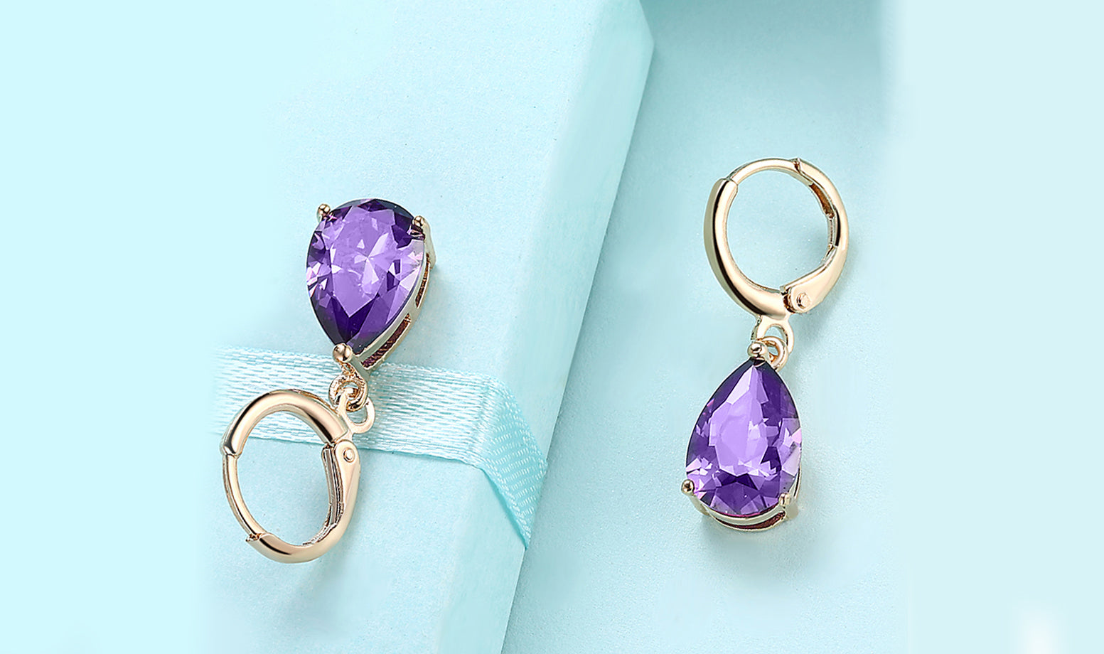 Elegant 14K gold plated pear cut drop earrings in blue, purple, and white options, showcasing their sleek design and high-quality craftsmanship.
