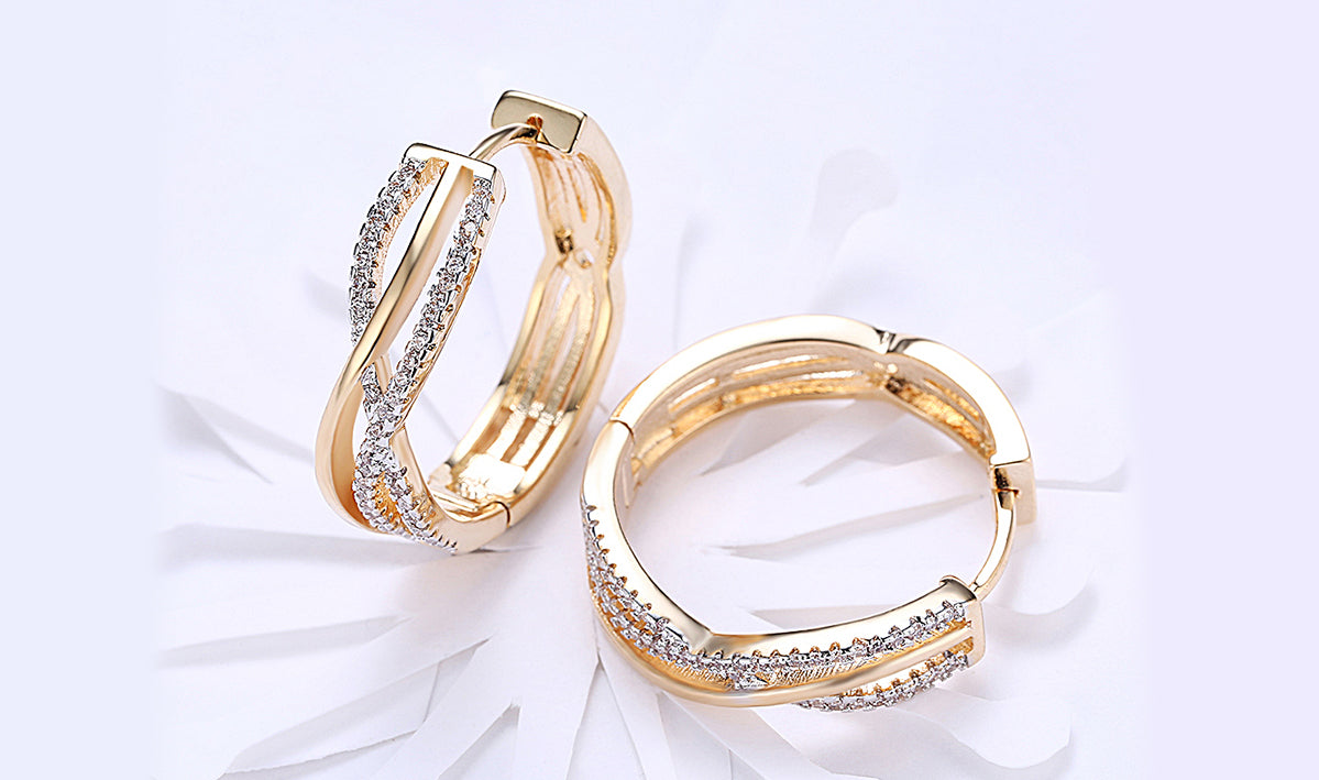 Elegant 14K gold plated clip-on earrings featuring white sapphire stones in a twisted abstract design.