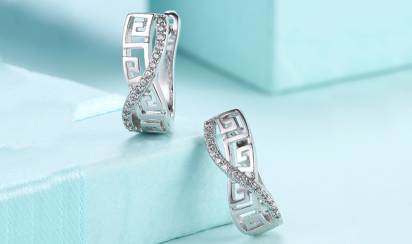 Elegant 14K white gold plated curved hinged earrings featuring a Greek key design with white Elements stones.
