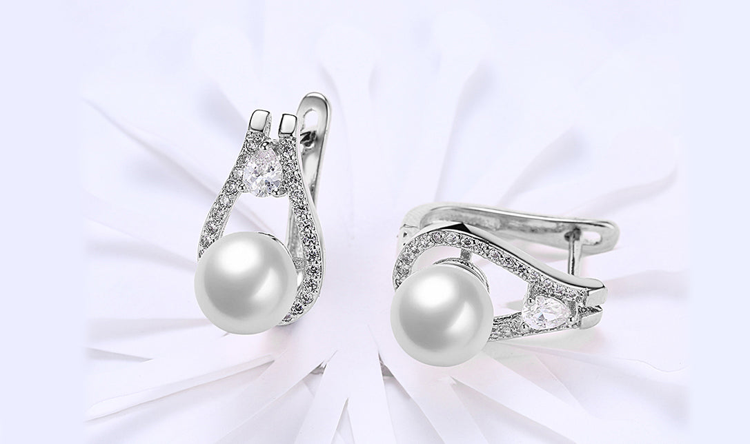 Elegant 14K white gold plated clip-on earrings featuring white sapphire stones and freshwater pearls in a pear cut design.