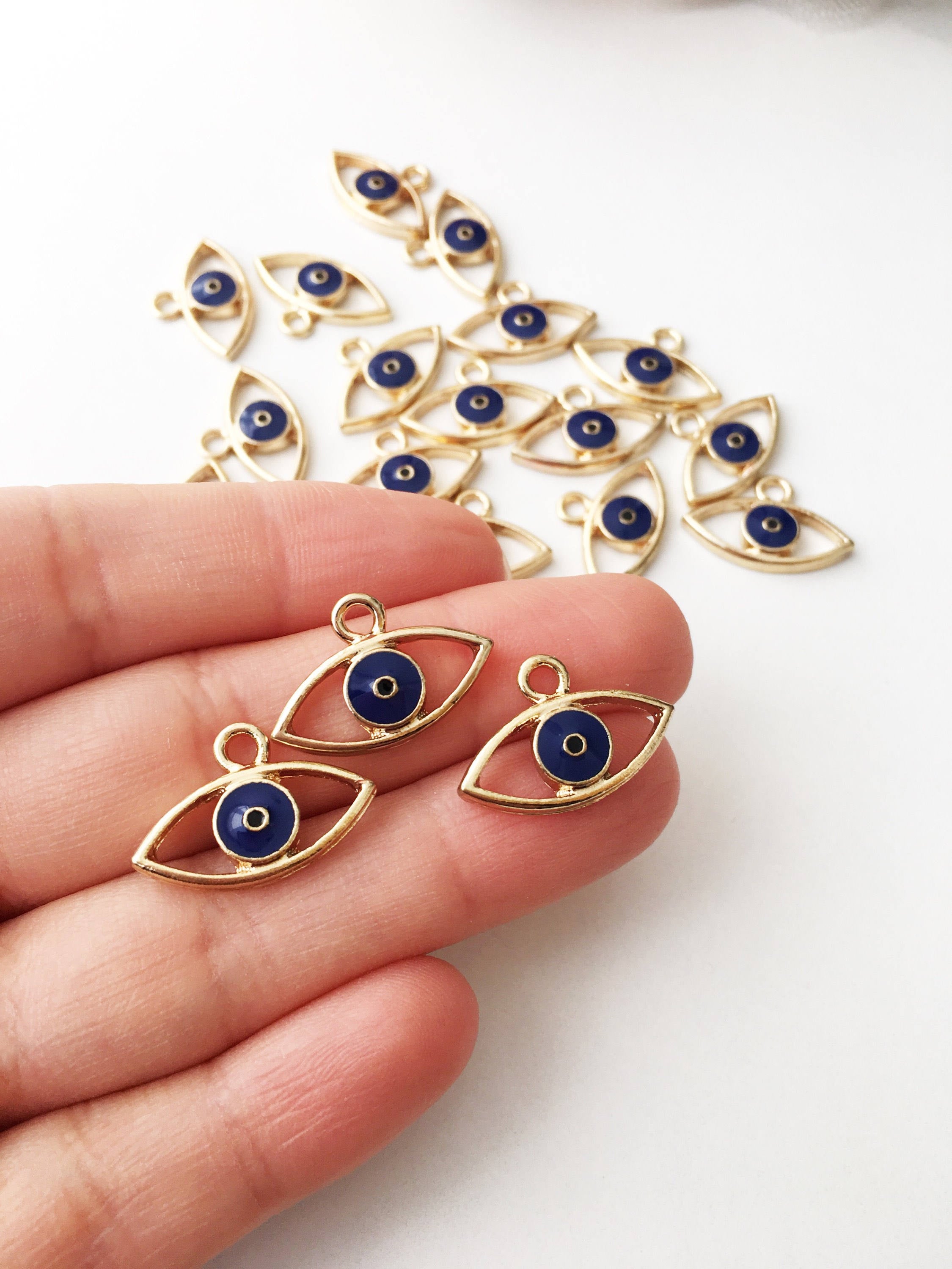 Two blue evil eye charms made of brass, featuring a 20mm size and 2mm hole, symbolizing protection and good fortune.