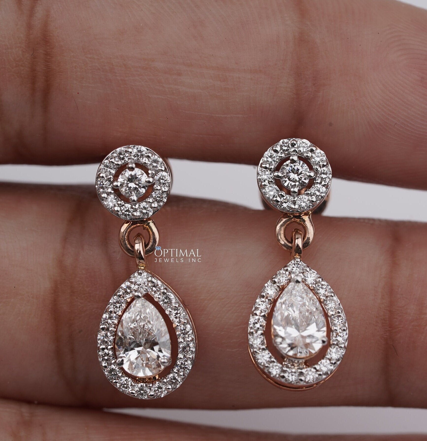 Elegant 2.00 CTW Round and Pear Lab-Grown Diamond earrings in a two-stone halo design, showcasing brilliant sparkle and modern elegance.