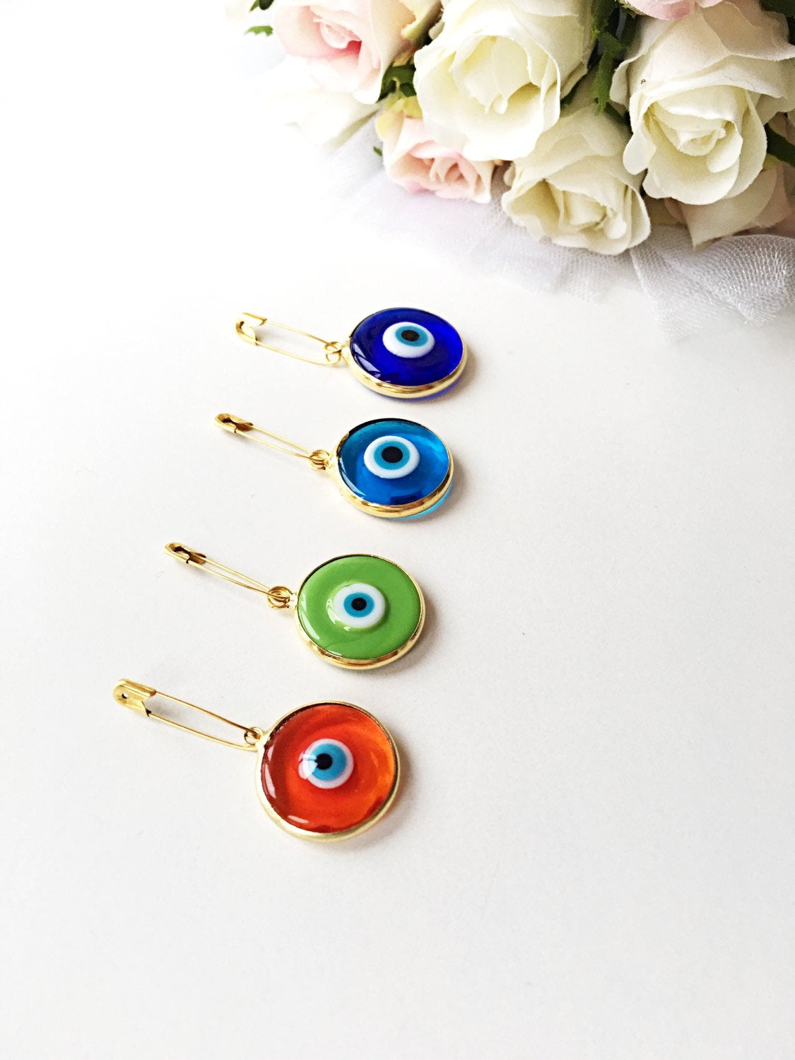 Gold plated 28mm evil eye safety pin with big enamel design, available in four colors for baby protection.