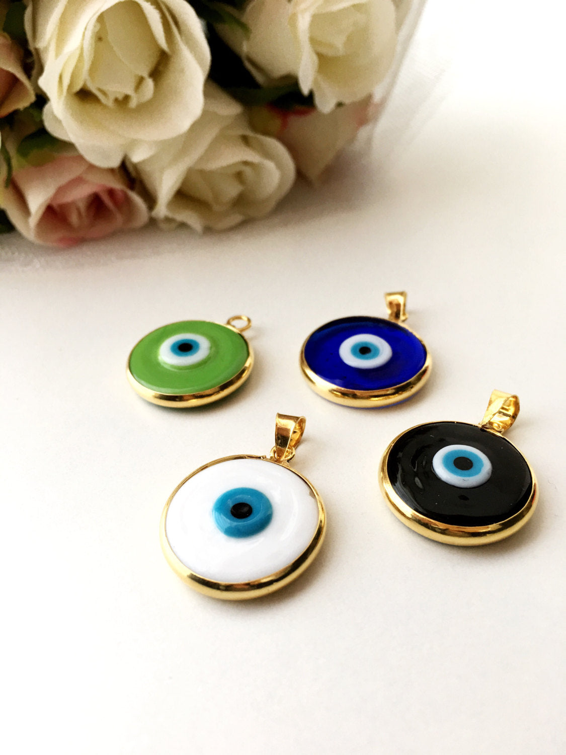 Two glass evil eye beads with gold plating, showcasing dark blue and opaque blue colors, perfect for jewelry making.