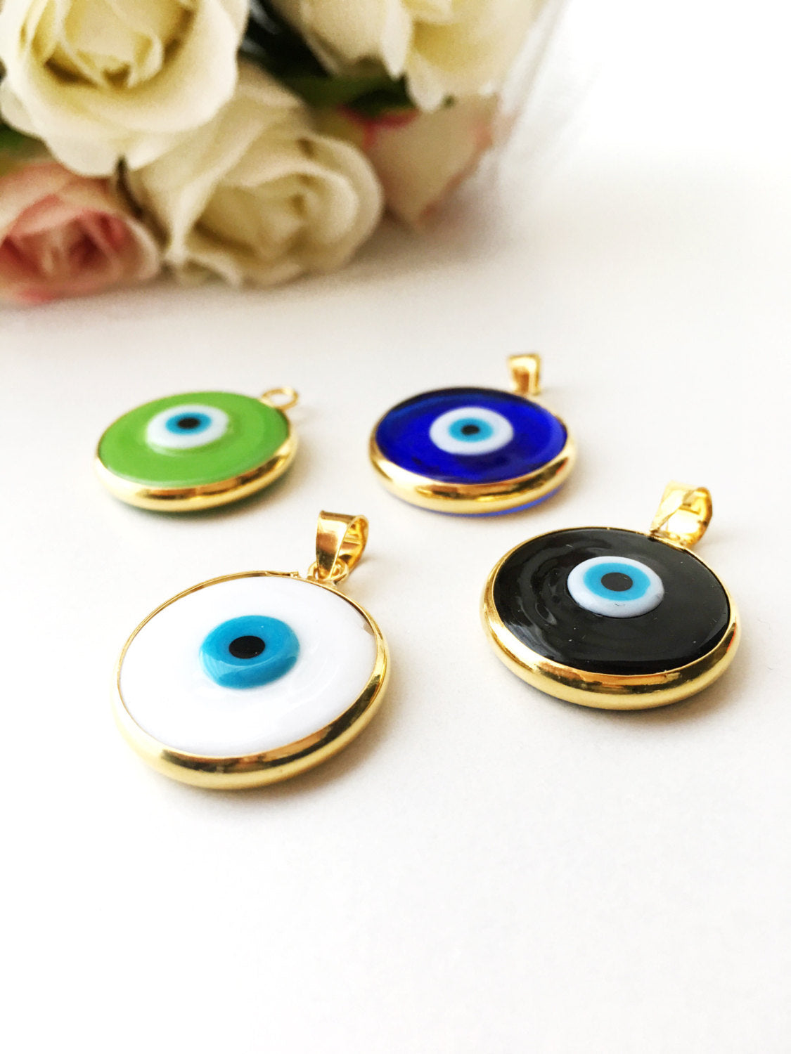 Two glass evil eye beads with gold plating, showcasing dark blue and opaque blue colors, perfect for jewelry making.