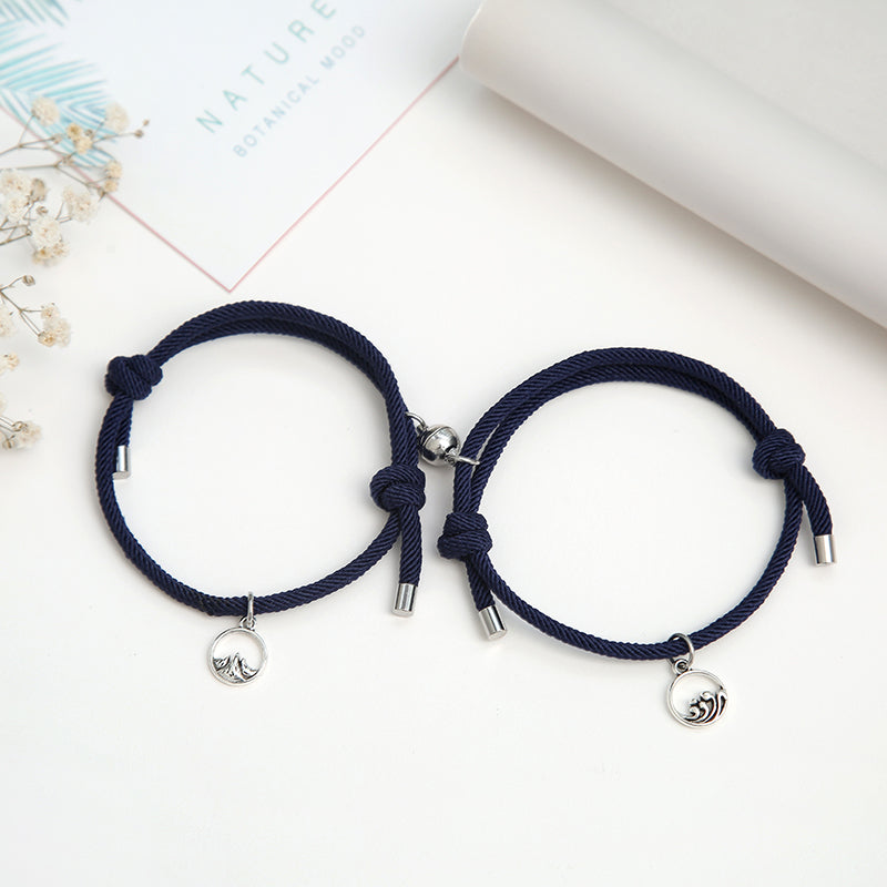 A pair of stylish alloy couple bracelets featuring magnetic attraction balls, symbolizing love and connection.